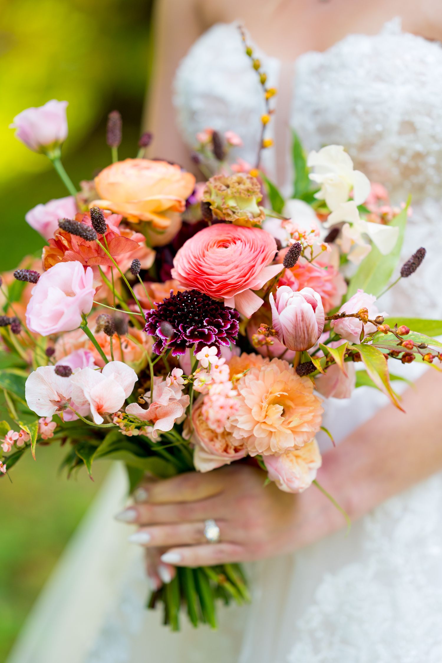 Beautiful wedding bouquet with pink and peach ranunculus flowers and greenery.