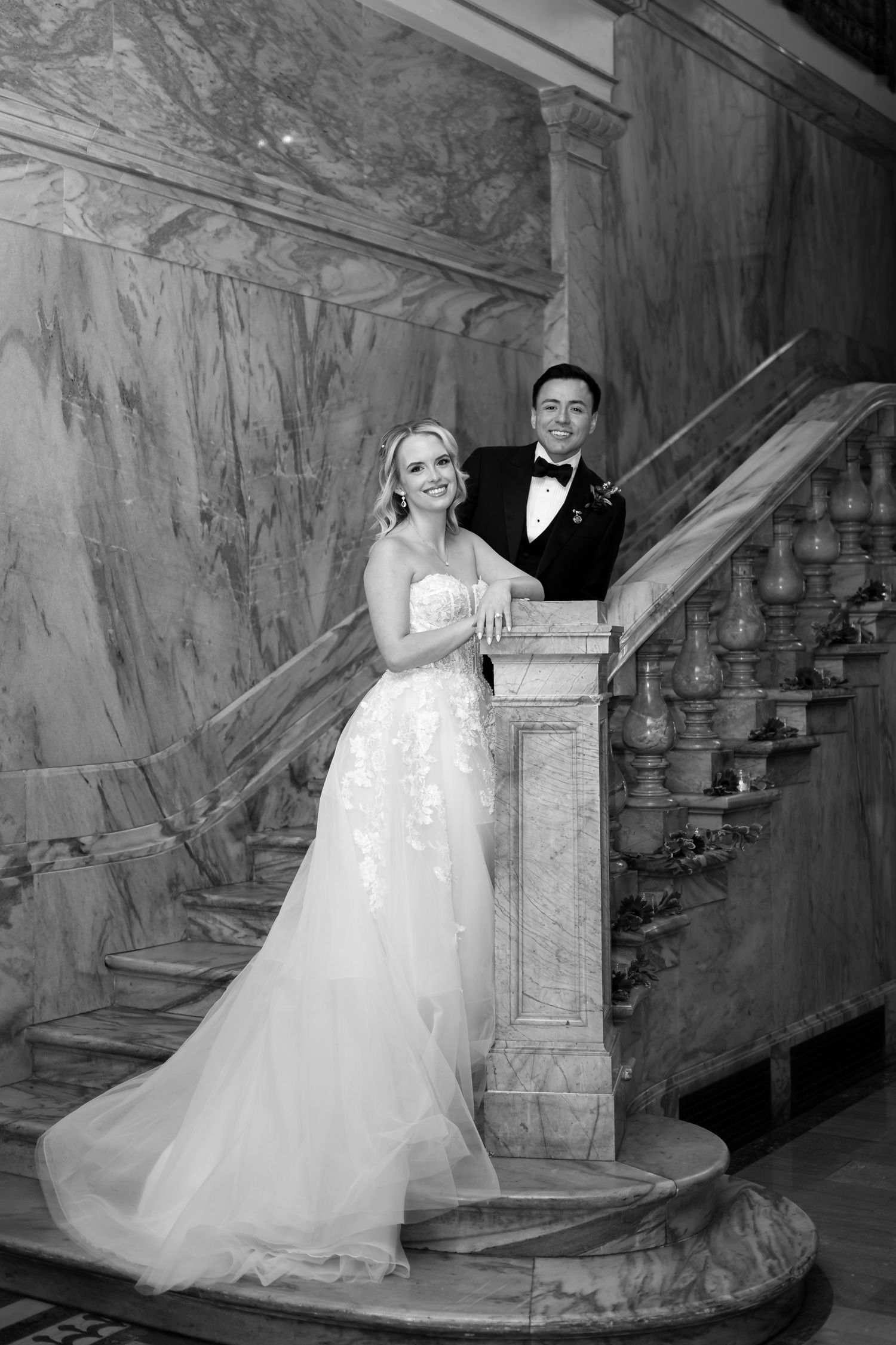 Black and white wedding photos showcase a couple posing on an elegant vintage staircase.