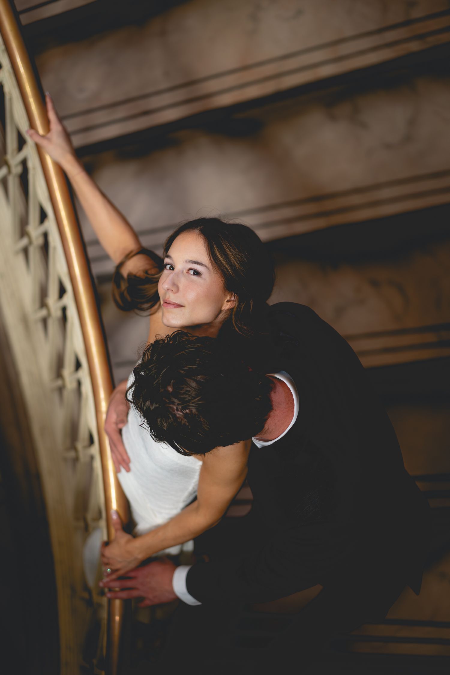 Artistic black and white photo of couple dancing on staircase at Hartford City Hall.