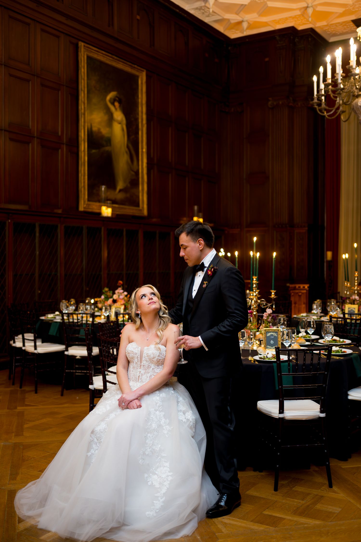 Romantic dance in elegant wood-paneled ballroom with candlelit tables.