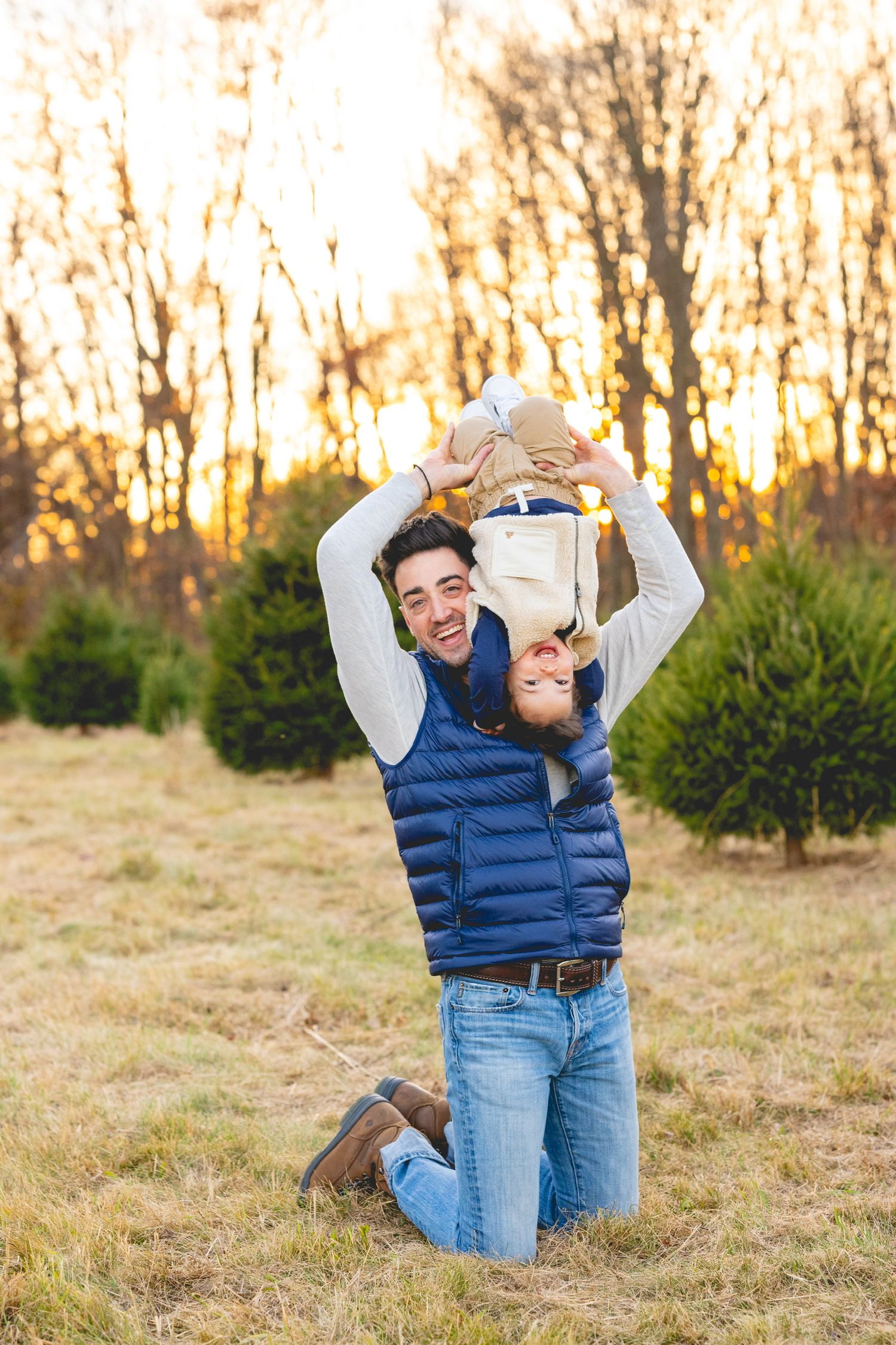 Playful couple in casual winter wear having fun in a field at sunset.