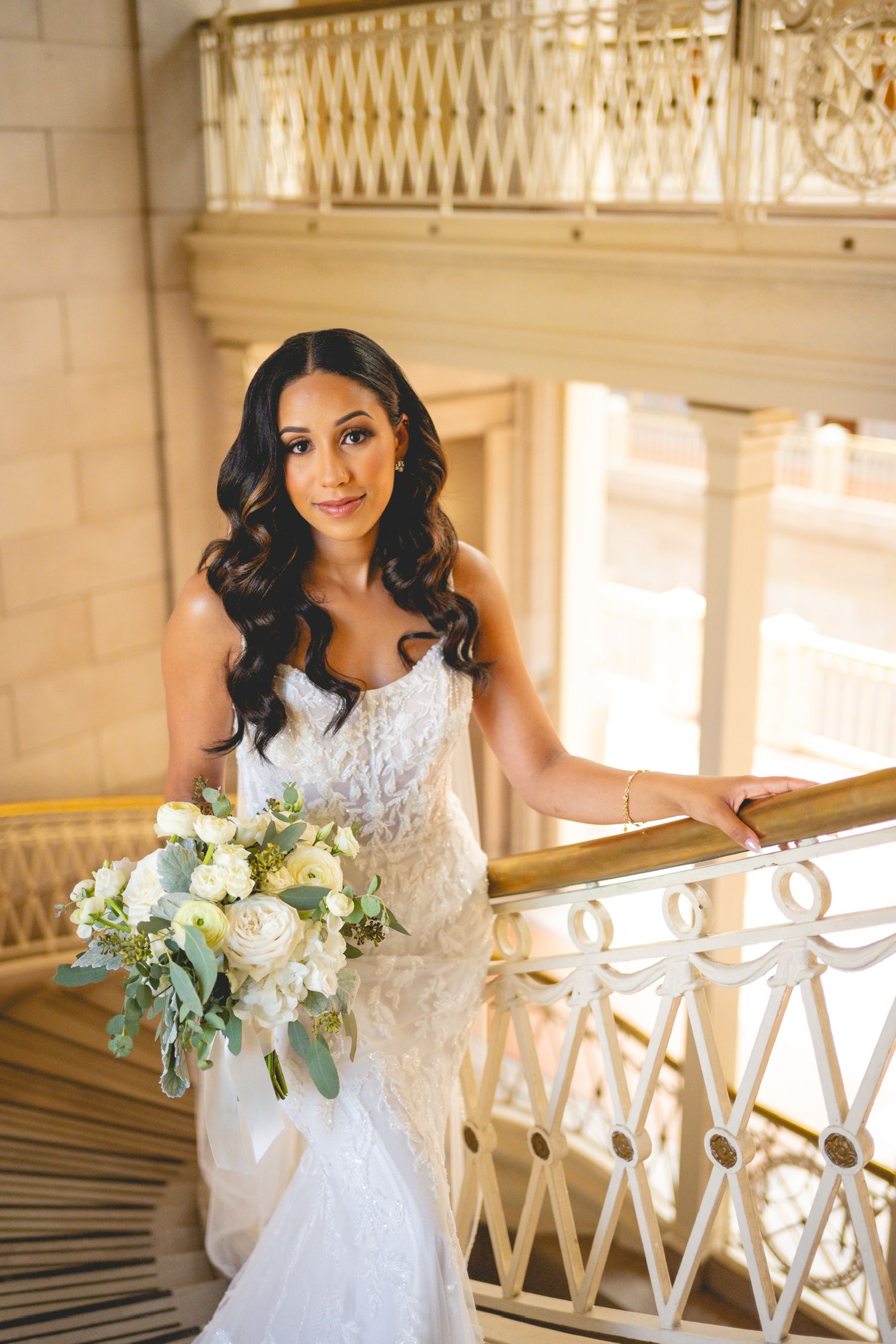 Bridal portraits along ornate white balustrade with bouquet.