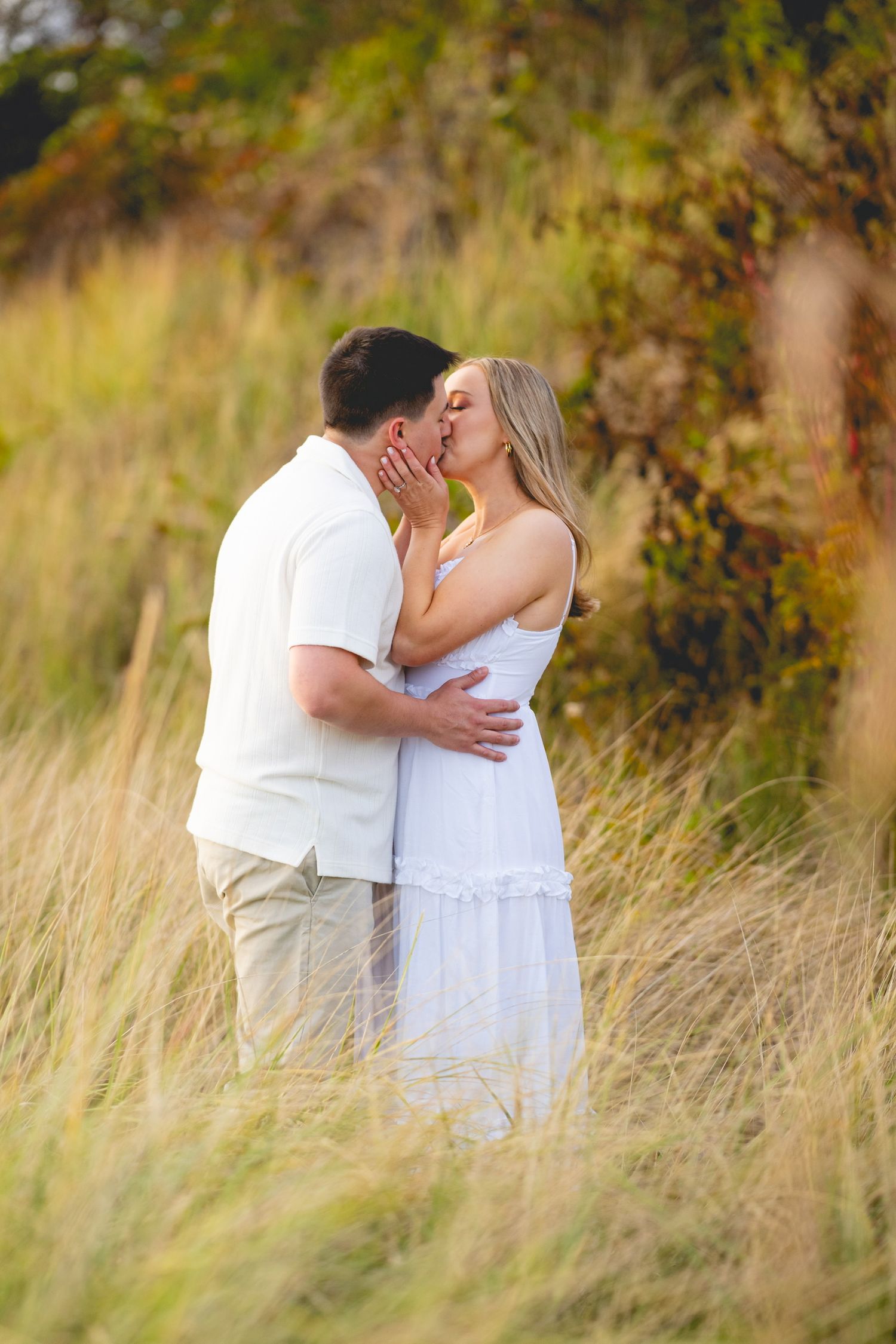 Intimate moment between couple among tall beach grass at Harkness Memorial State Park in Waterford, Connecticut.