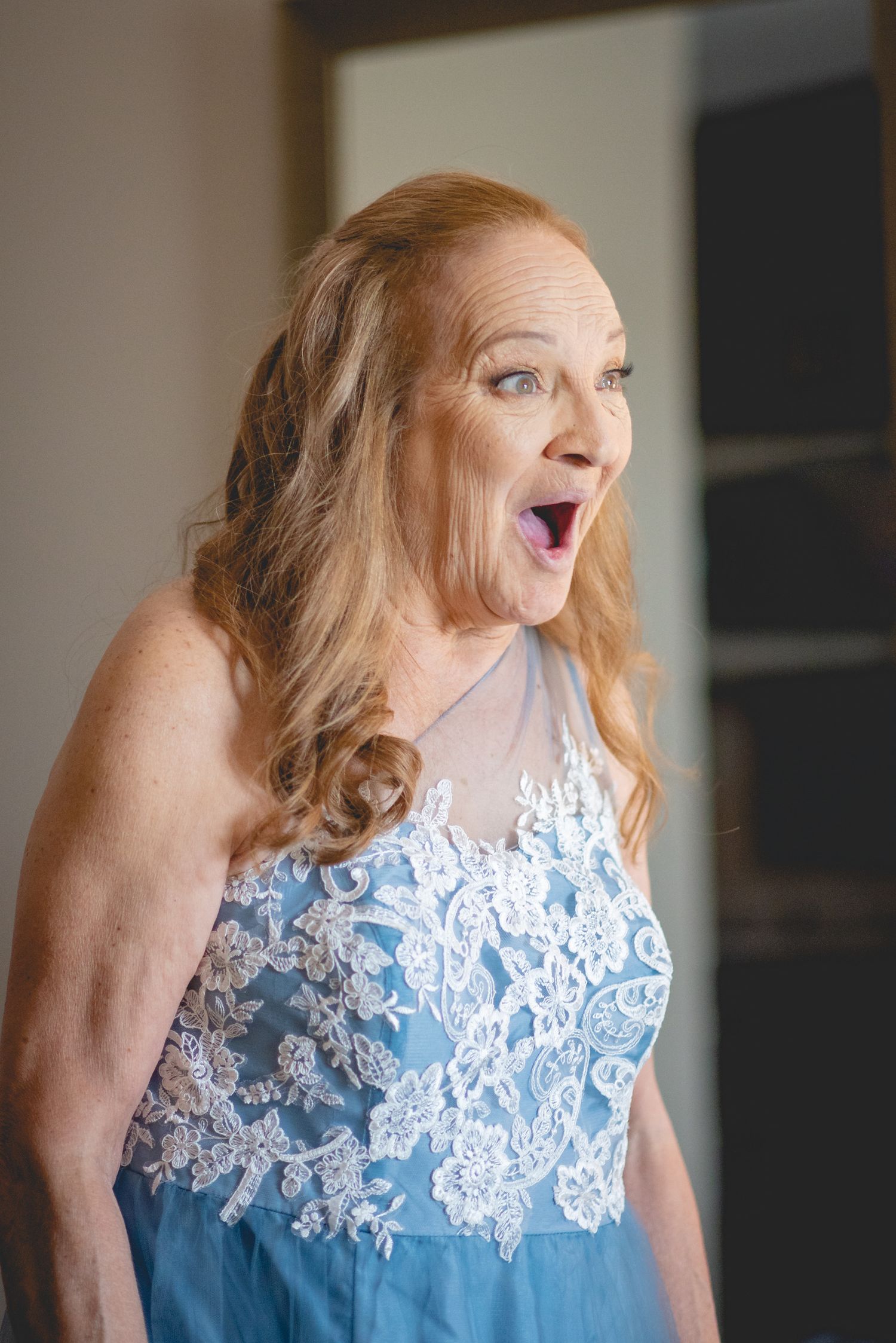 Person wearing a light blue dress with white lace detail showing joyful expressions.