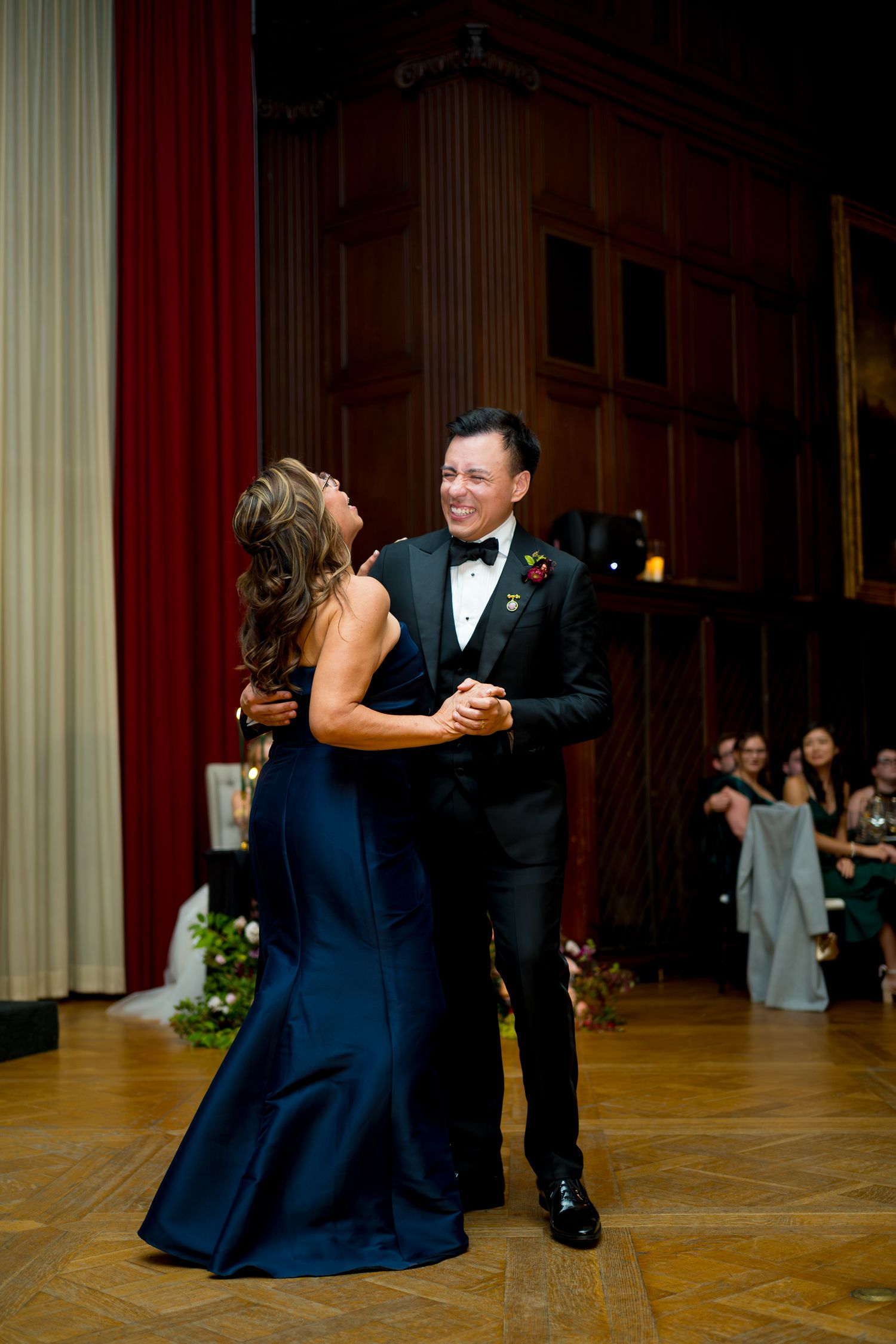 Couple shares an intimate dance moment on an elegant ballroom floor during their wedding reception.