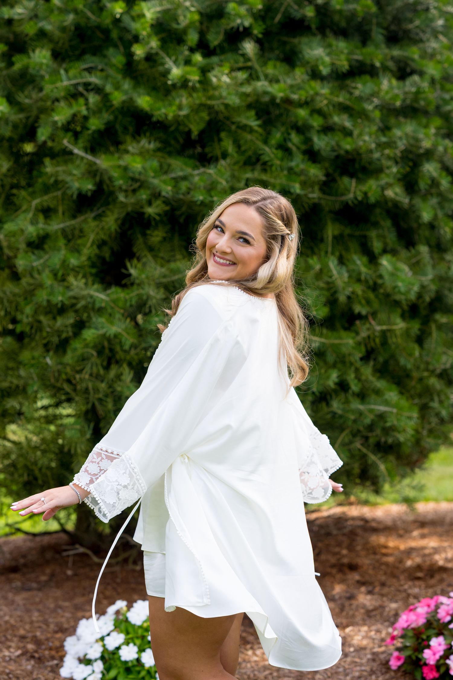 A playful sequence of a bride twirling in a white wedding dress against a garden backdrop with pink flowers.