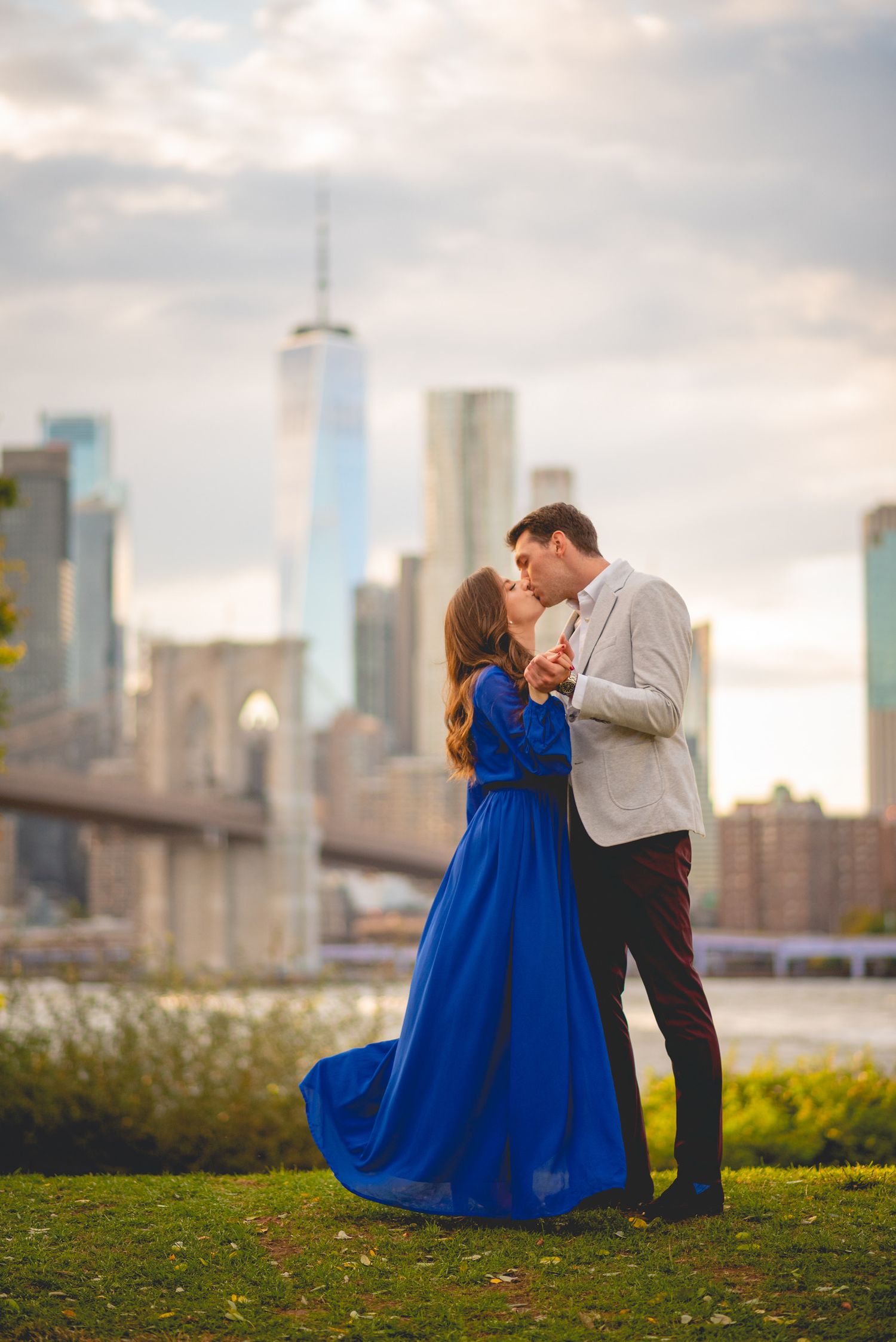 A romantic moment against the New York City skyline with tall buildings in the background.