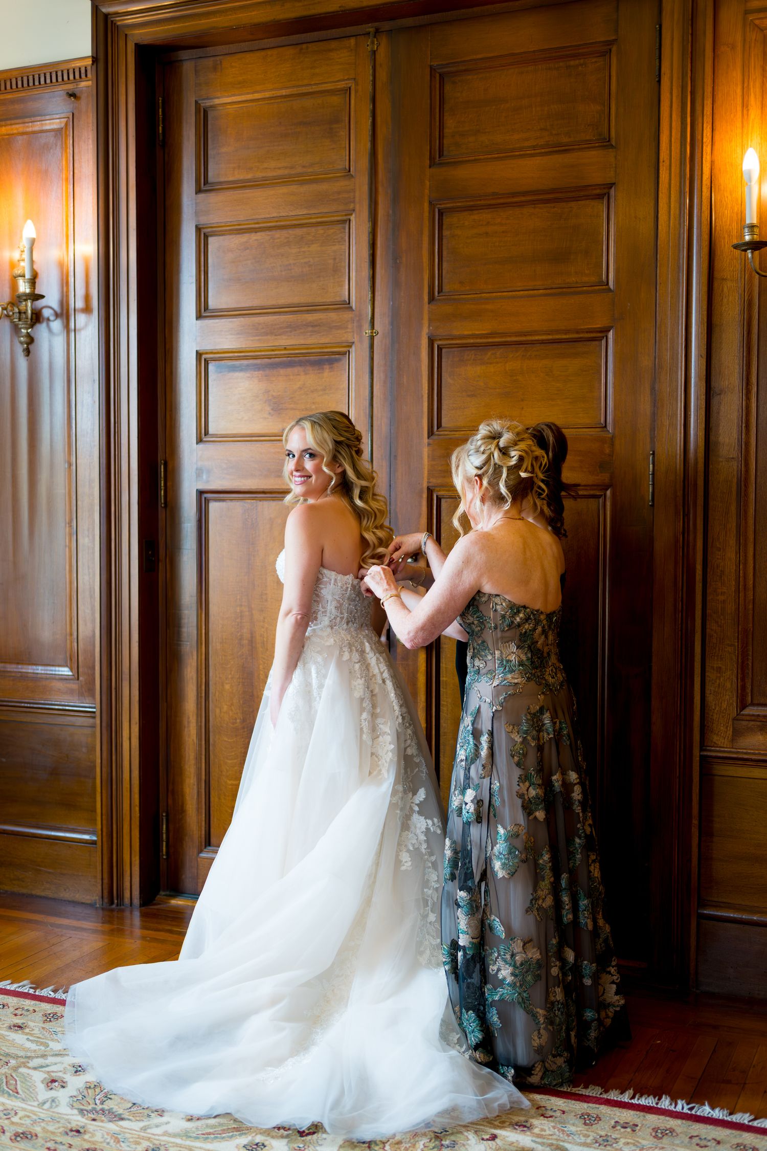 A wedding dress fitting scene in an elegant wood-paneled room with warm lighting and ornate details.