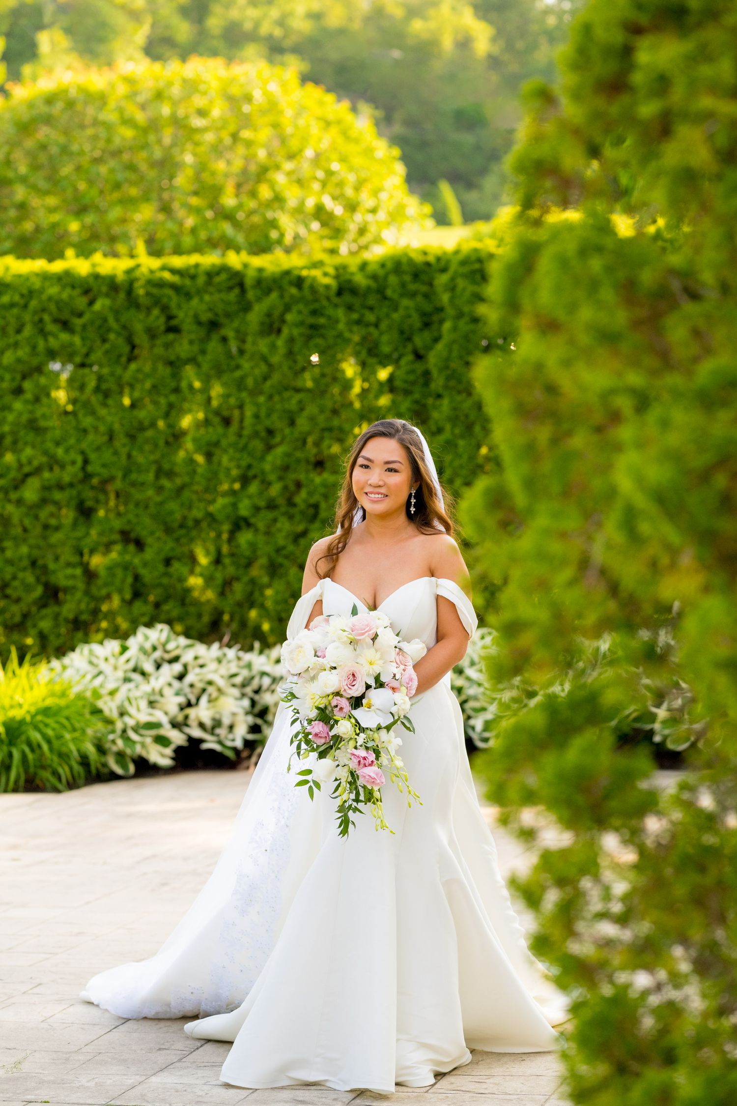 Wedding portrait in lush garden setting with vibrant yellow and green foliage.