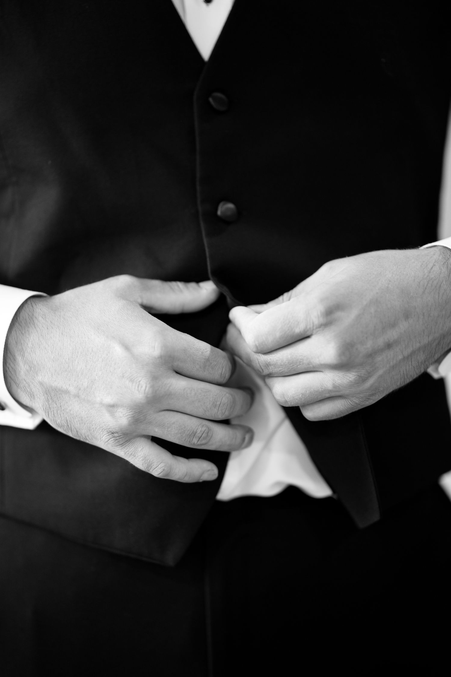 A black and white close-up series showing hands adjusting formal attire.