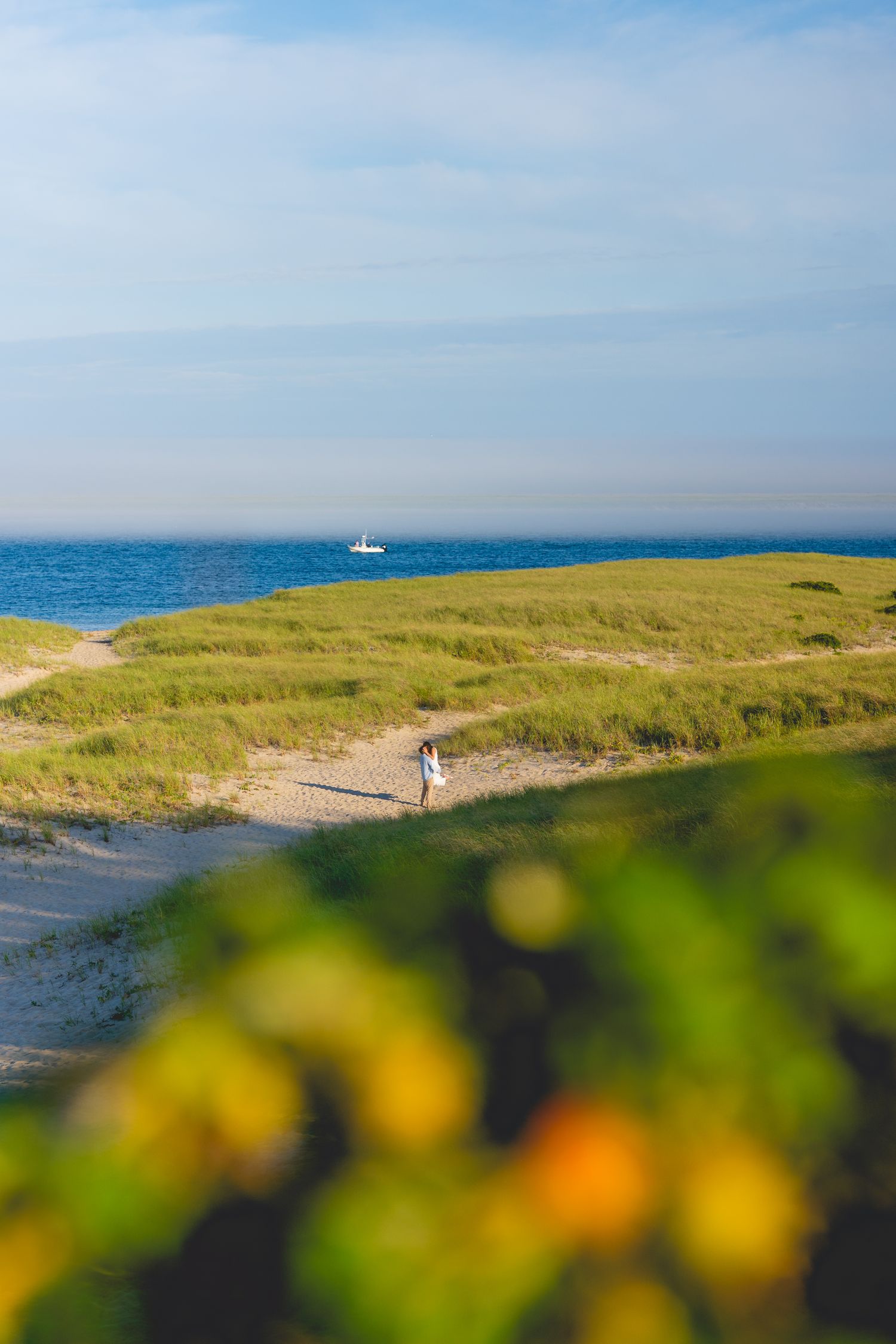 Coastal landscape with a couple walking along Chatham Lighthouse Beach path in Chatham, Massachusetts