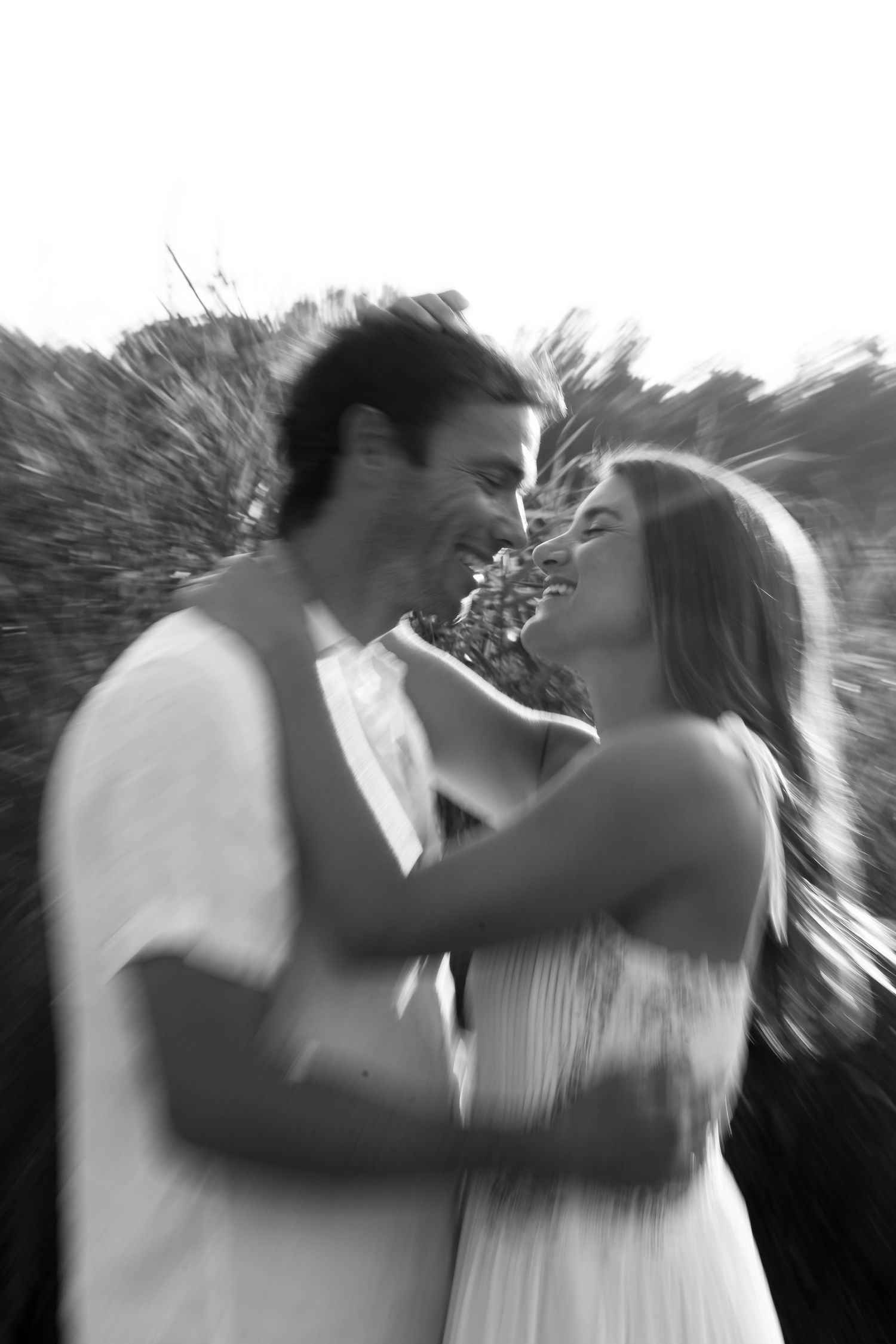 A series of black and white motion-blurred images showing two figures embracing and dancing together.