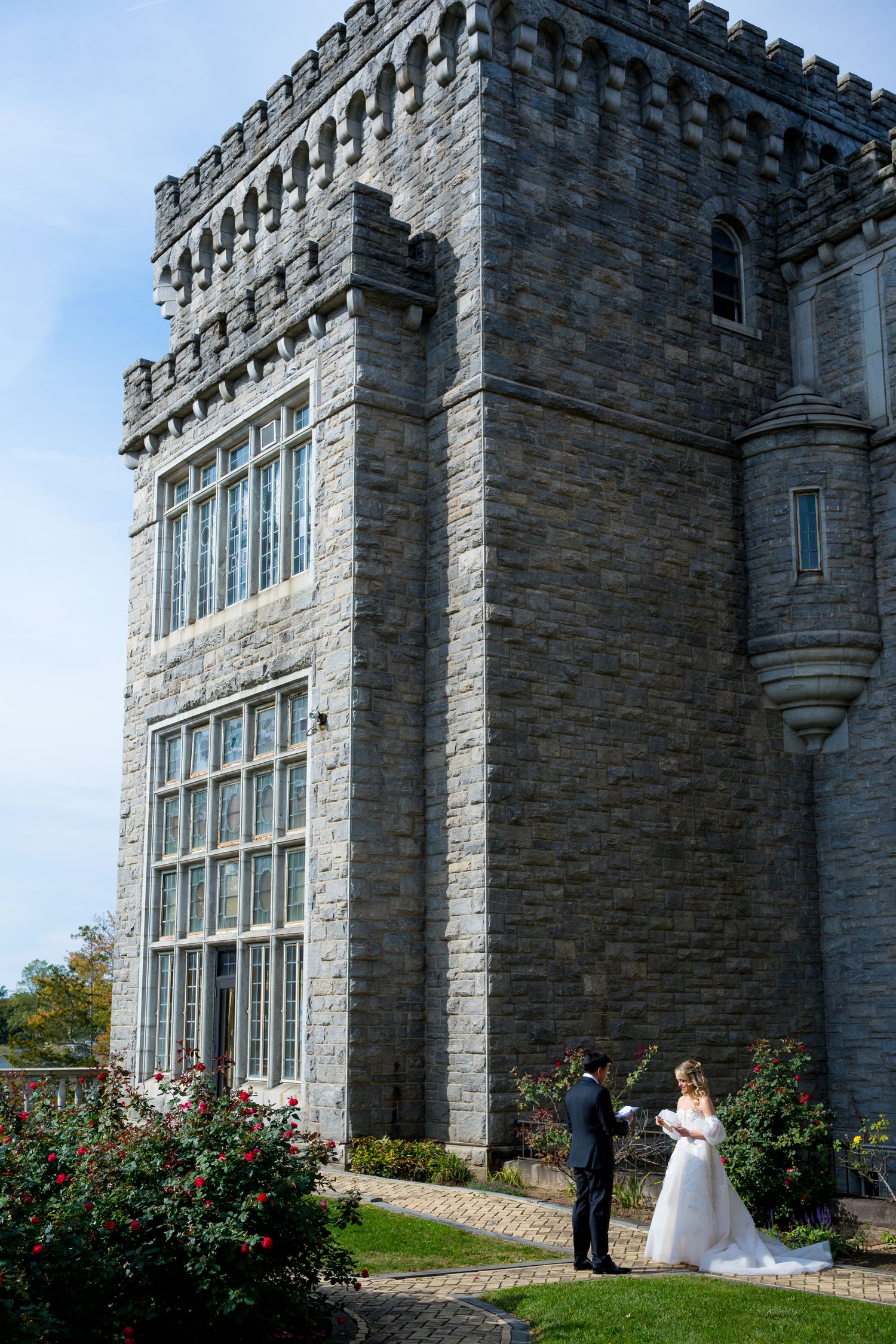 Reid Castle wedding venue in New York with stone architecture and blooming rose garden for first look between bride and groom.