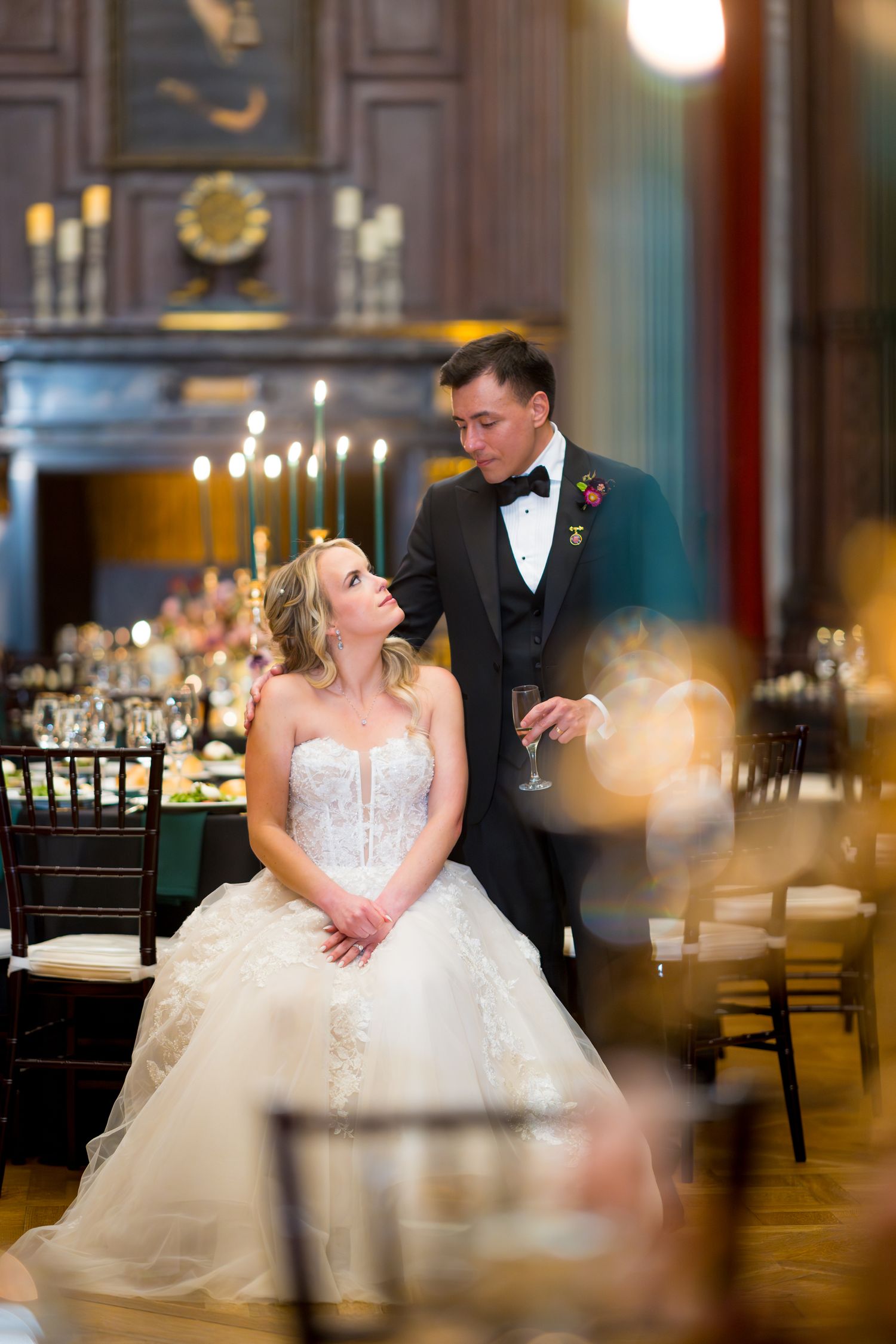 A bride and groom share intimate moments in an elegant ballroom setting with soft lighting and romantic ambiance.