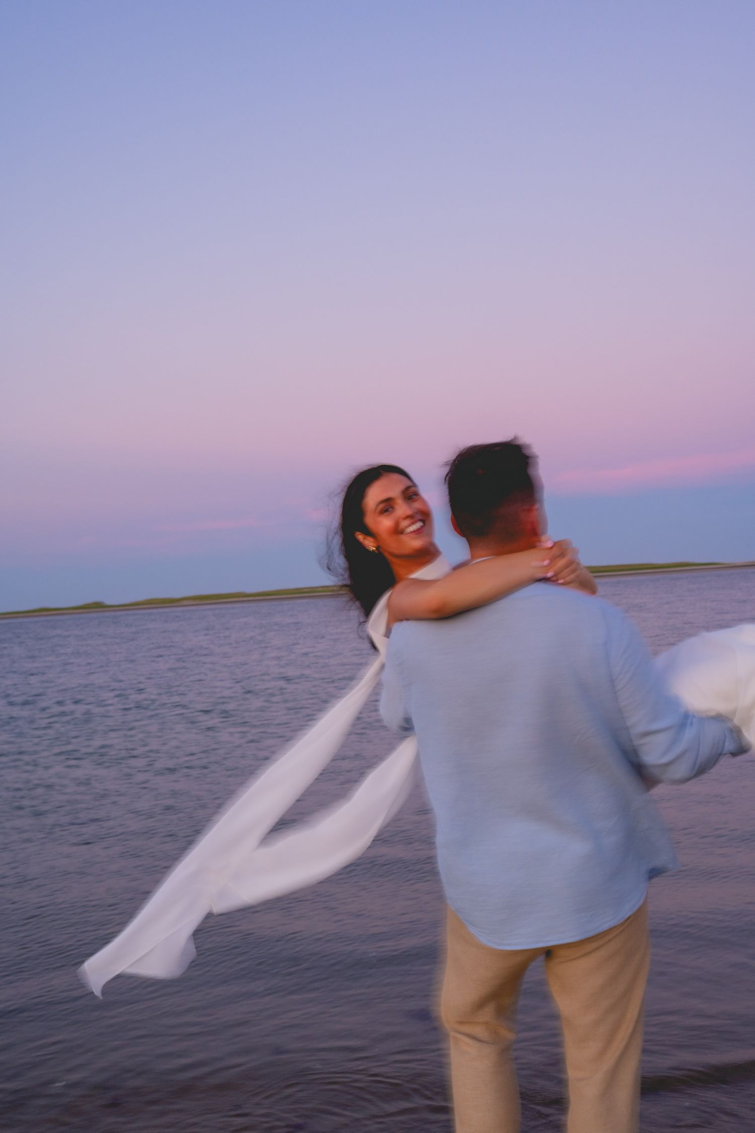 A couple dances together by the ocean during sunset in Cape Cod.