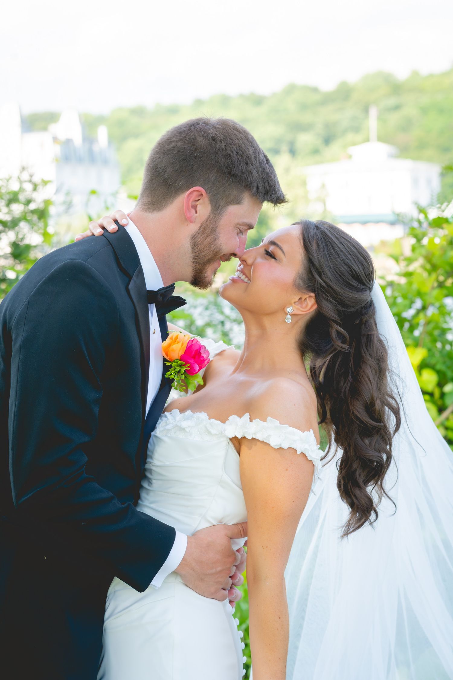 Romantic wedding moment captured against a scenic waterfront background.