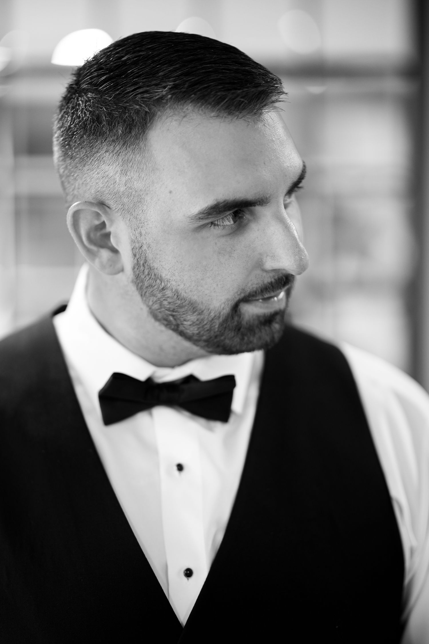 Profile view of a man in formal attire with a black bow tie.