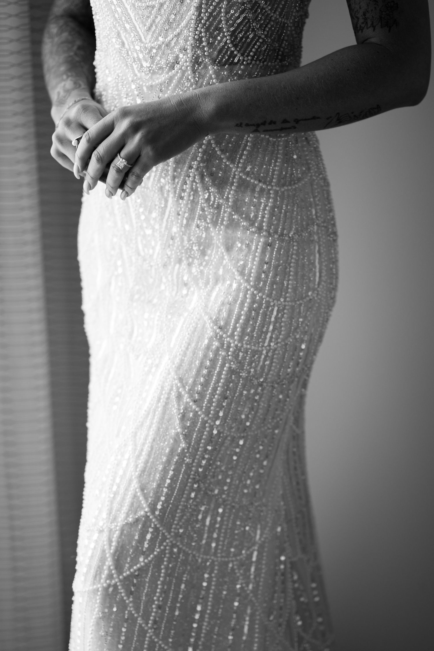 Close-up detail of beaded wedding dress showing intricate pattern and sparkly embellishments.