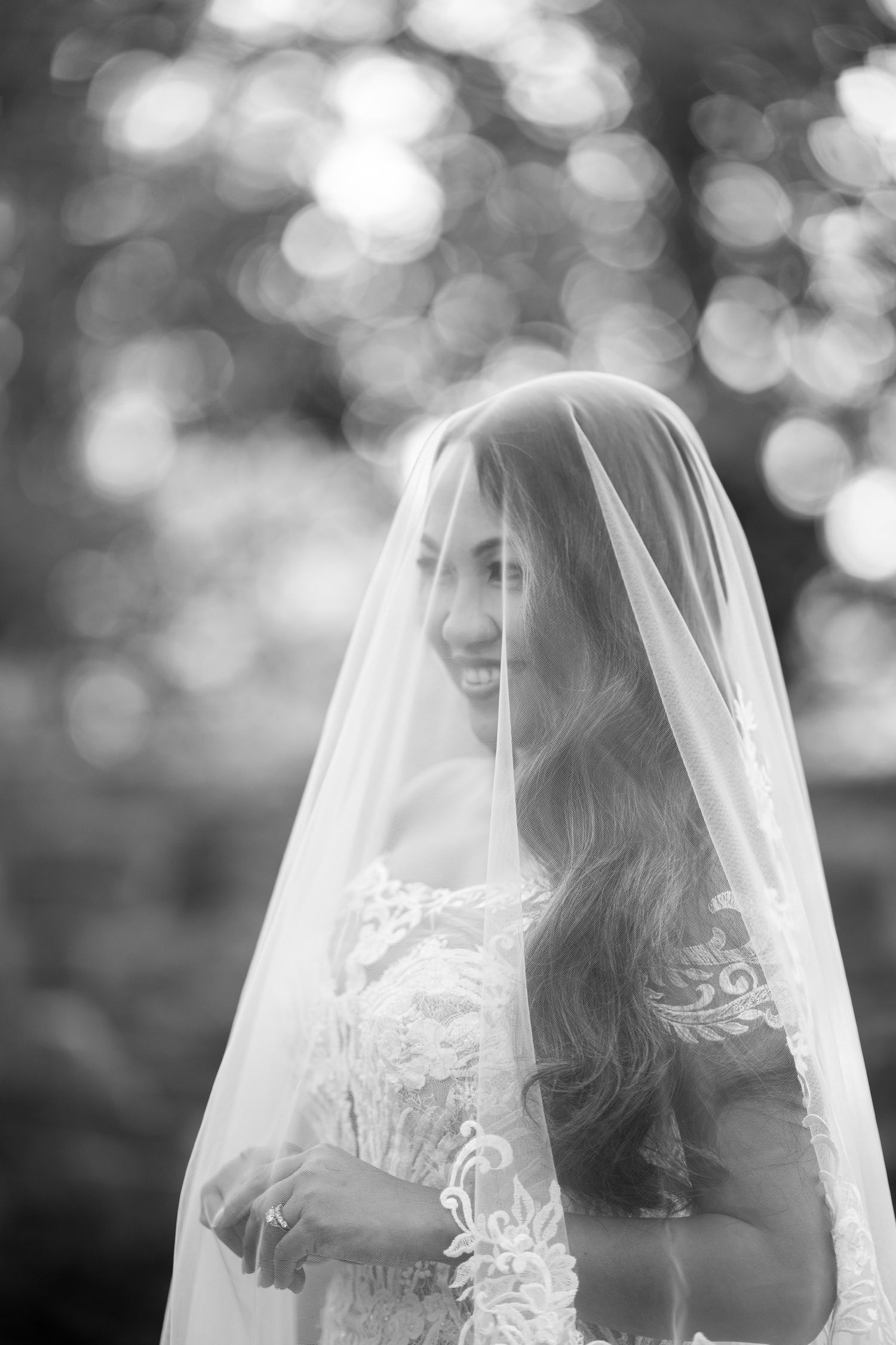 A dreamy black and white portrait of a bride wearing a delicate lace veil at Le Chateau in Westchester County, New York.