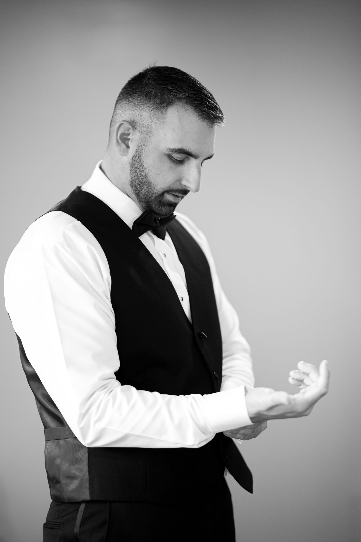 Black and white portrait series showing formal attire adjustments.