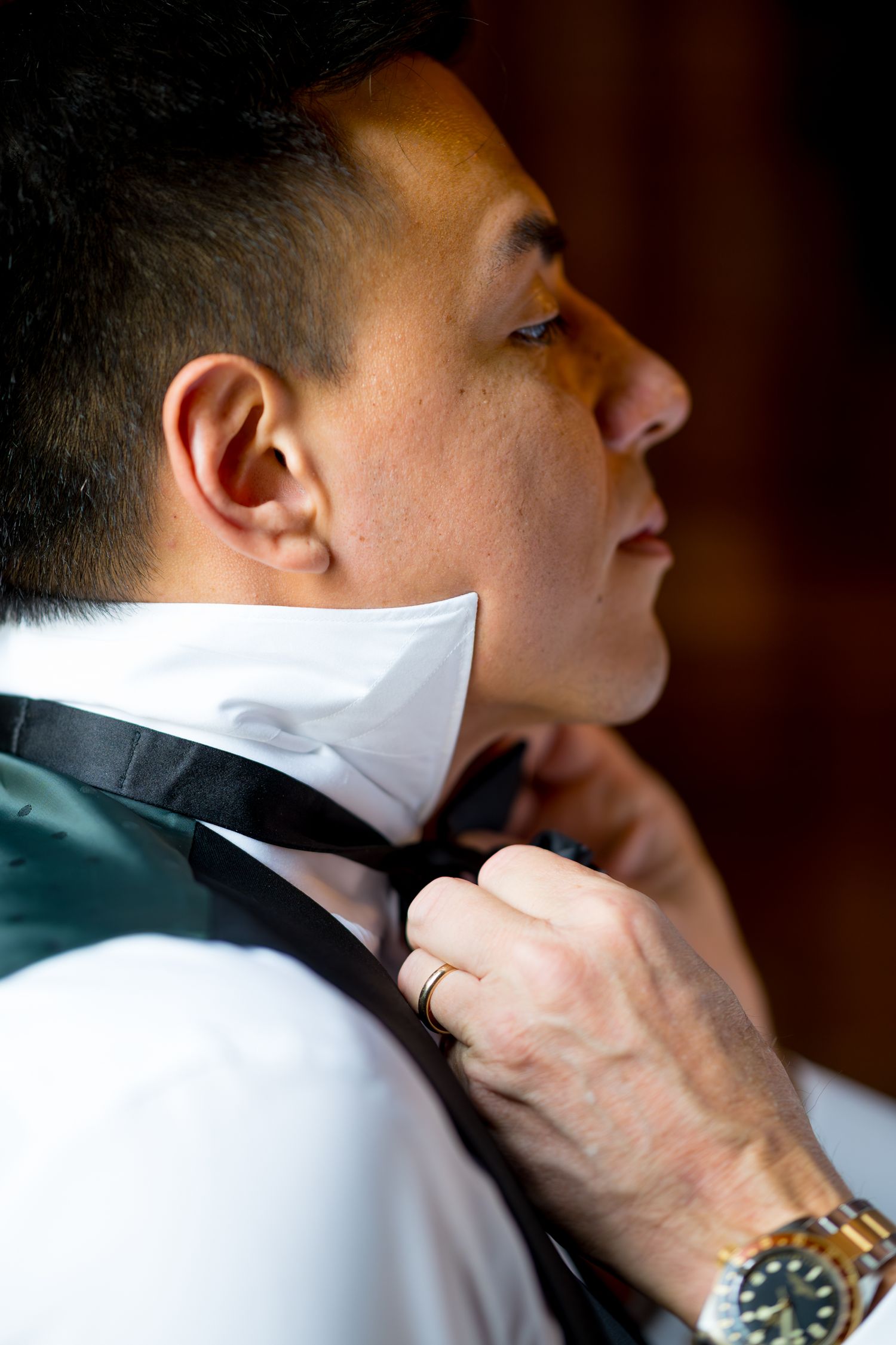 A series of photos showing hands adjusting a black bow tie and collar on a white dress shirt.