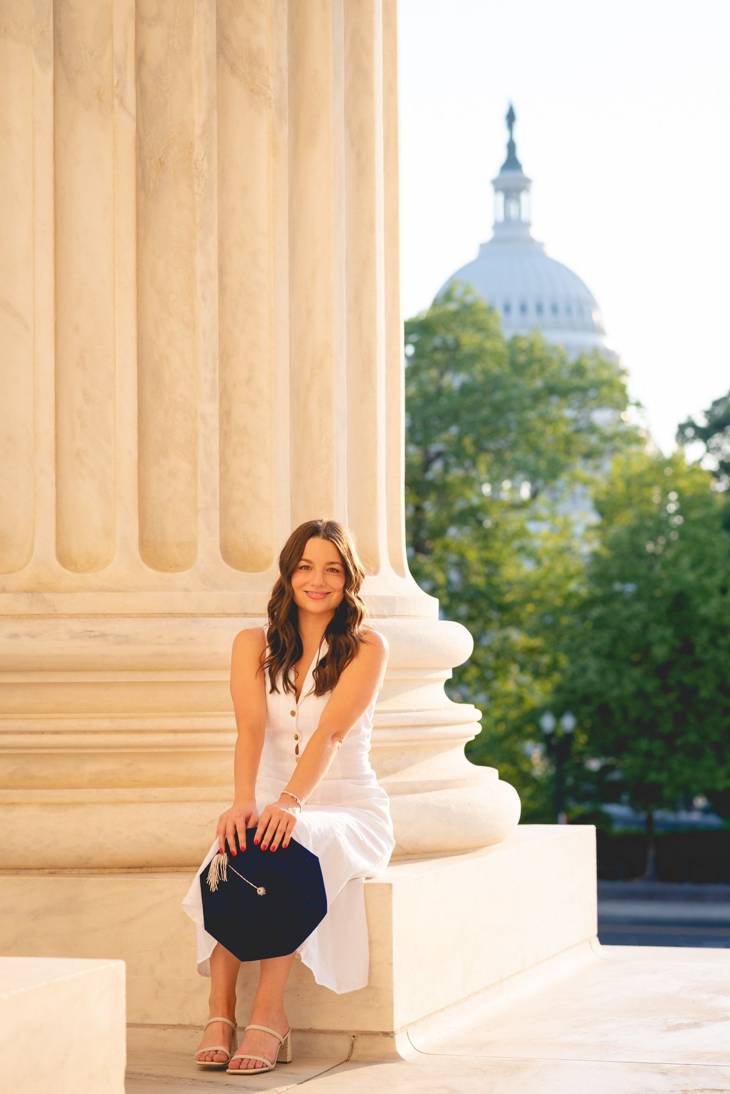 Graduation portraits taken among classical columns with Capitol building visible in background.