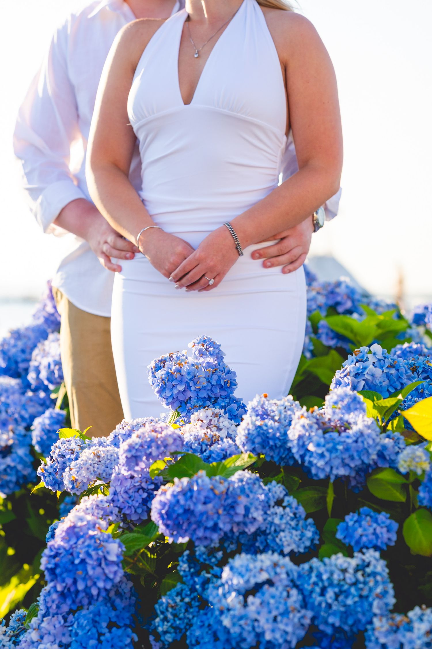 White dress and blue hydrangeas create an elegant coastal scene in Watch Hill, Rhode Island.