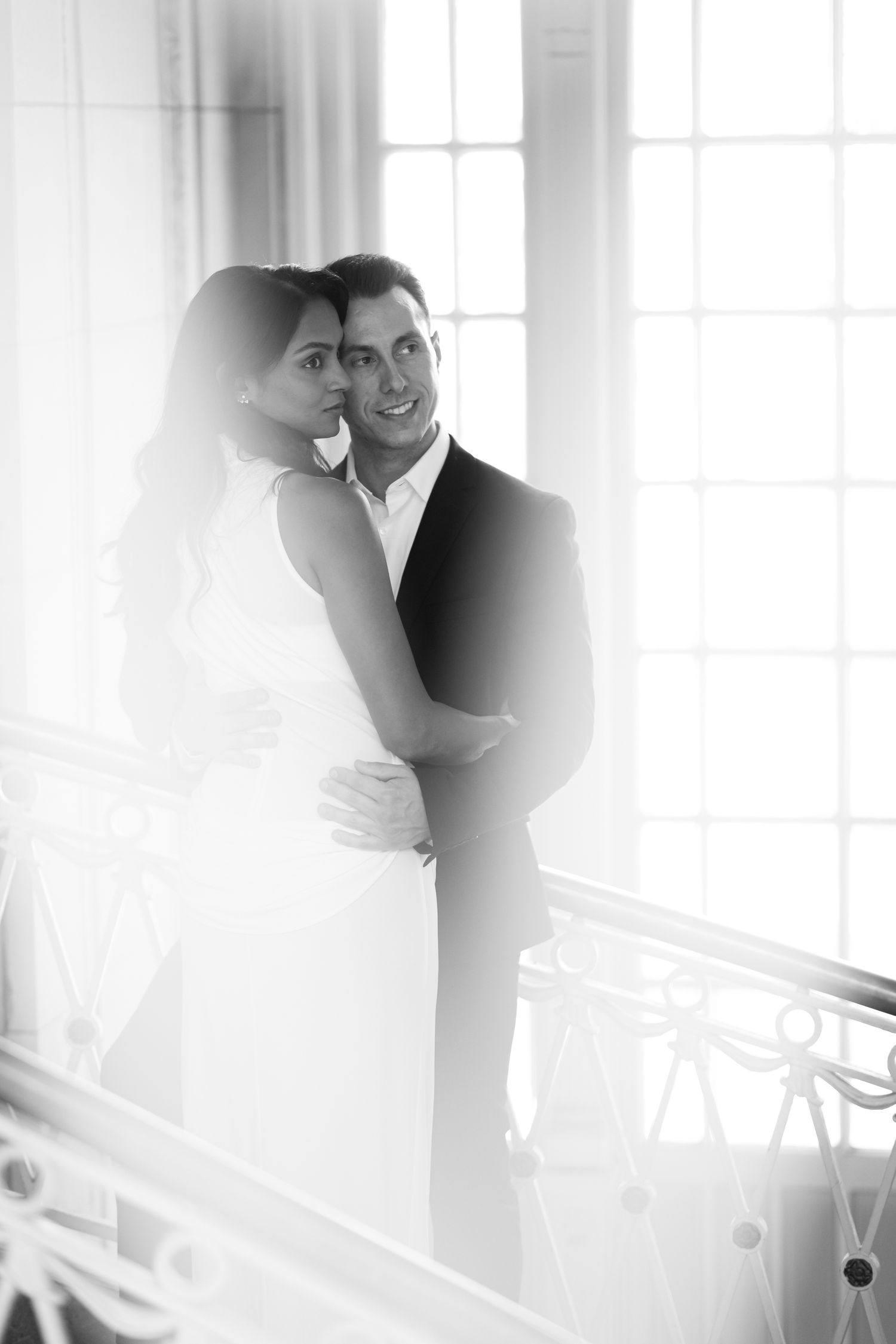 A dreamy, backlit couple shares an intimate moment near bright windows at Hartford City Hall.