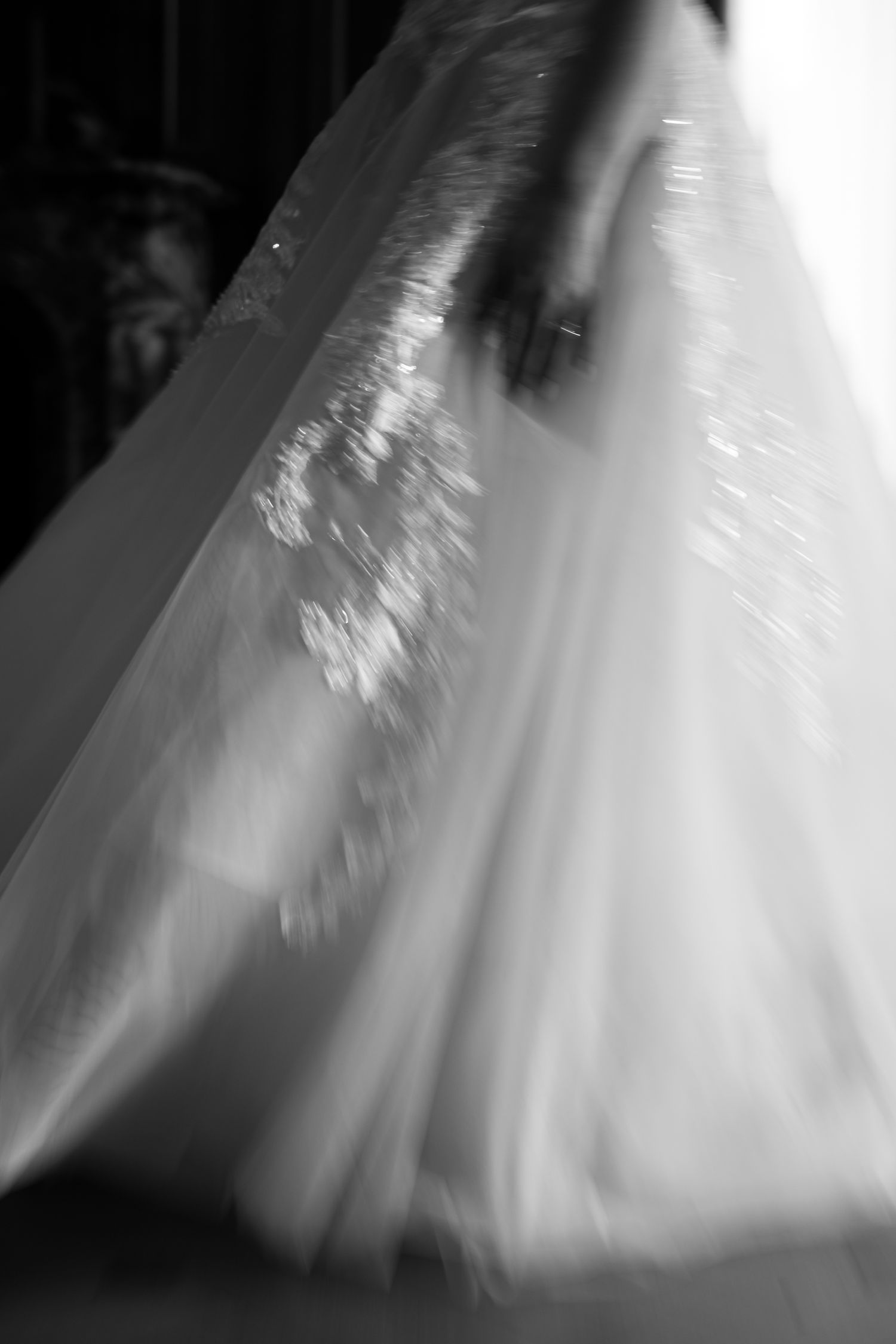 A series of motion-blurred images showing the flowing movement of a white wedding dress skirt during a dance or spin.