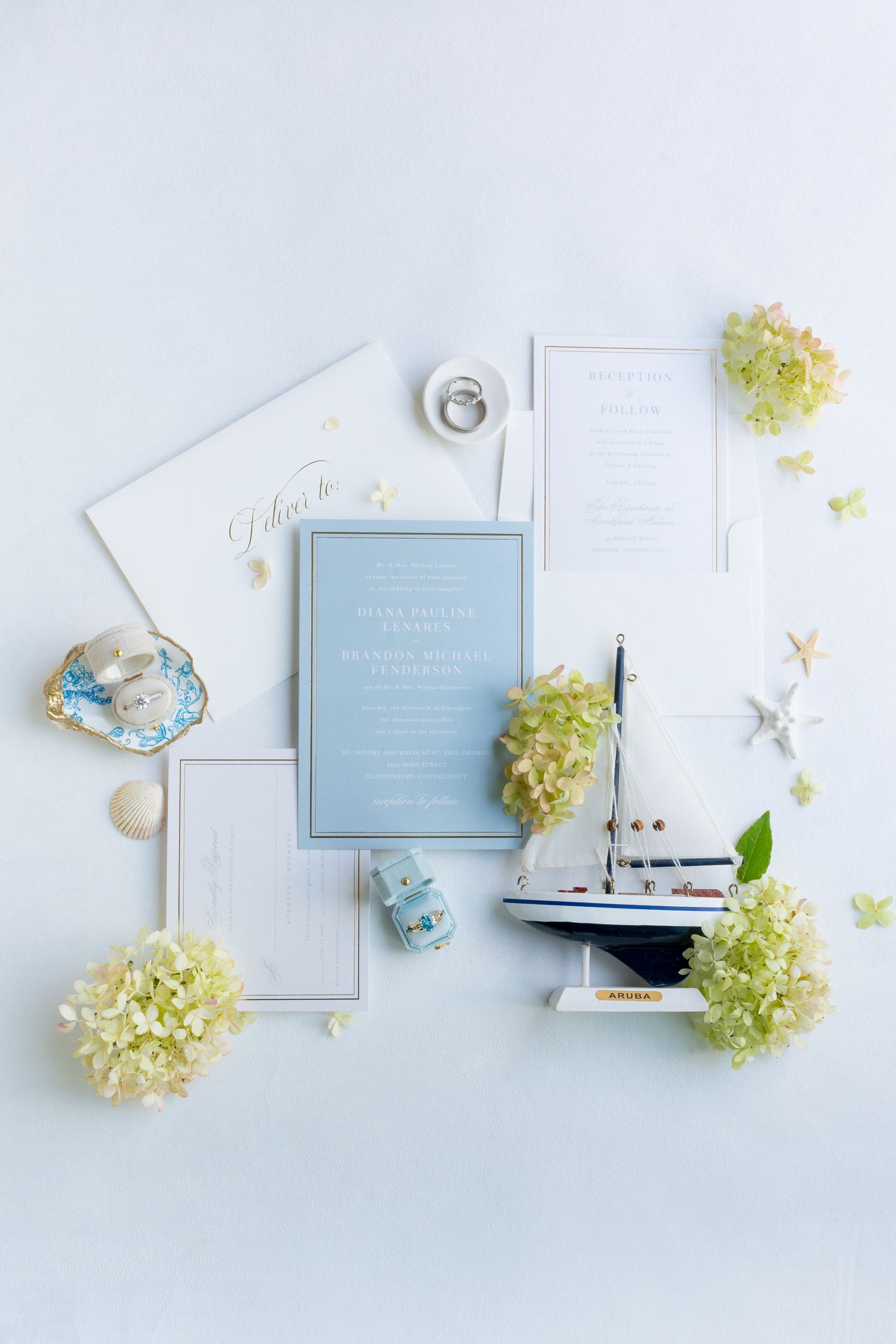 Elegant wedding invitation suite in light blue and white with floral accents and delicate details.