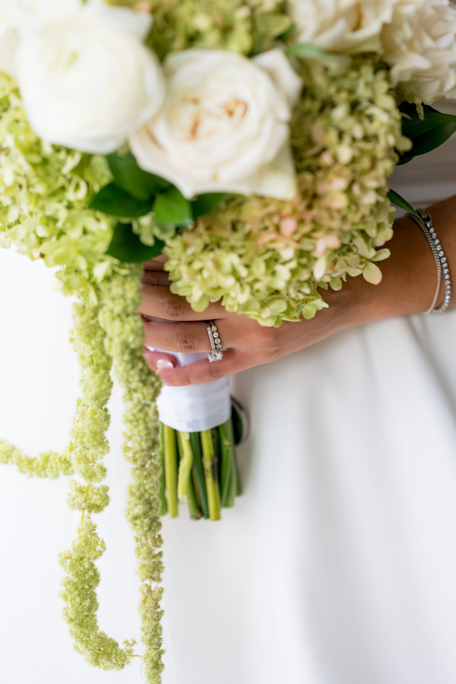 Elegant wedding bouquet with white roses and cascading green hydrangeas.