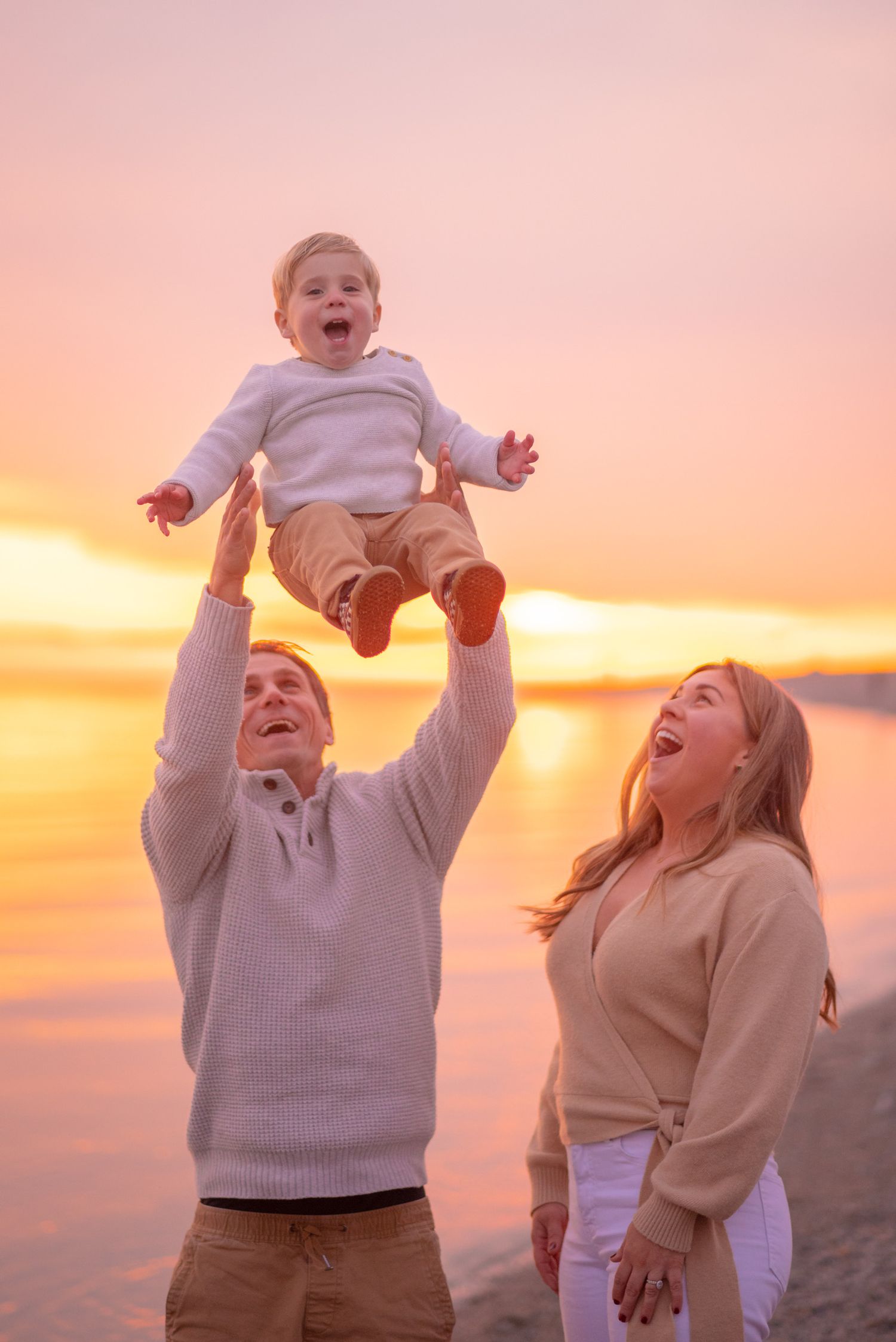 Joyful playtime against a stunning orange sunset sky at the beach.