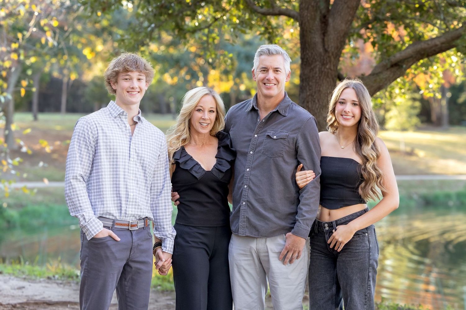 Family portrait session outdoors with multiple generations against natural backdrop.