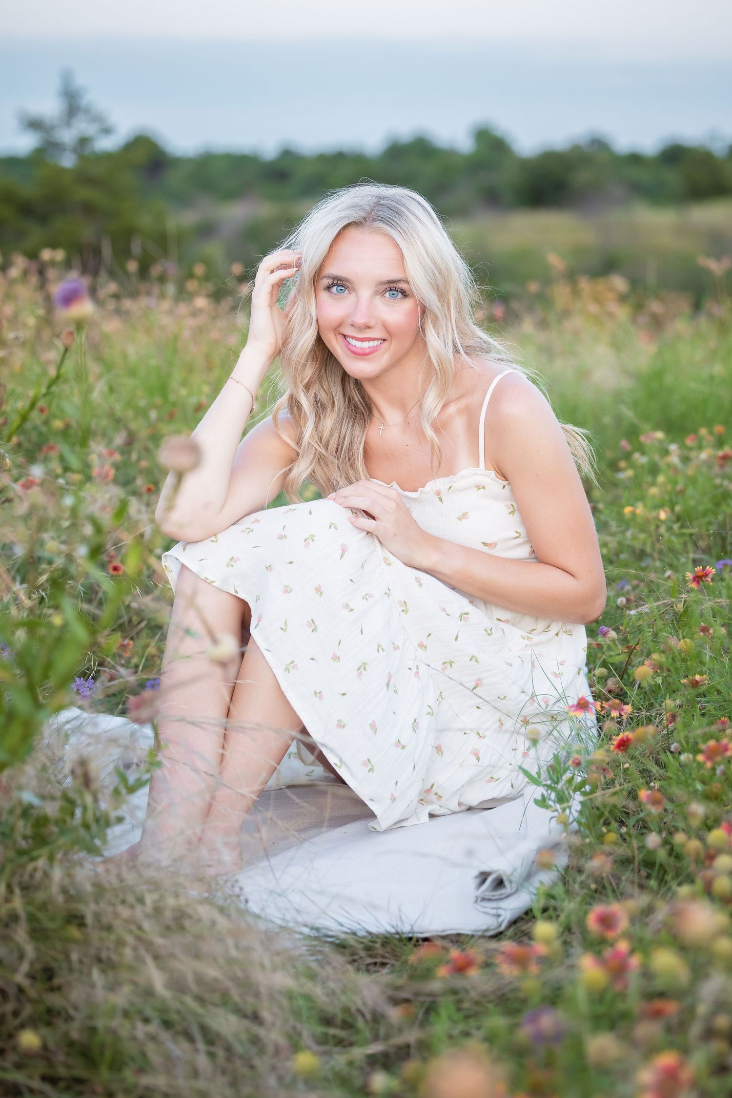 Dreamy outdoor portrait in a wildflower field wearing a white sundress and boots.
