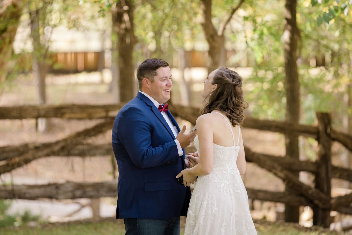 Couple shares tender moments during outdoor wedding photoshoot in wooded setting with natural lighting.