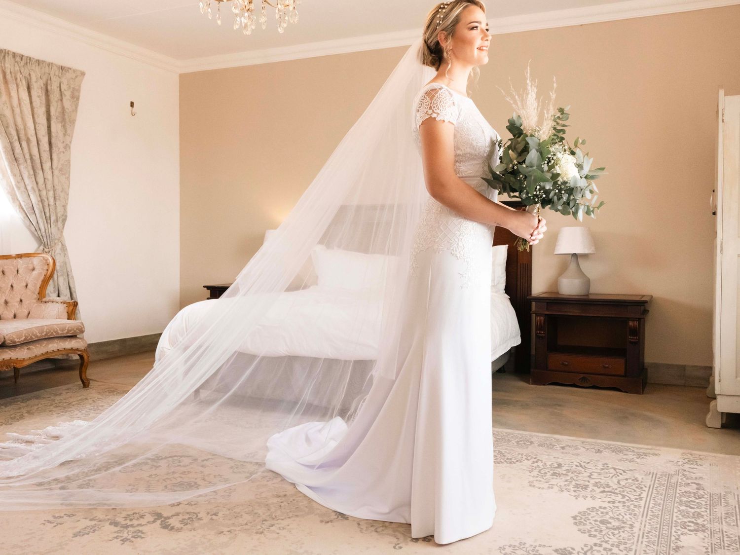 Bride holding her bouquet indoors with her wedding dress train spread out