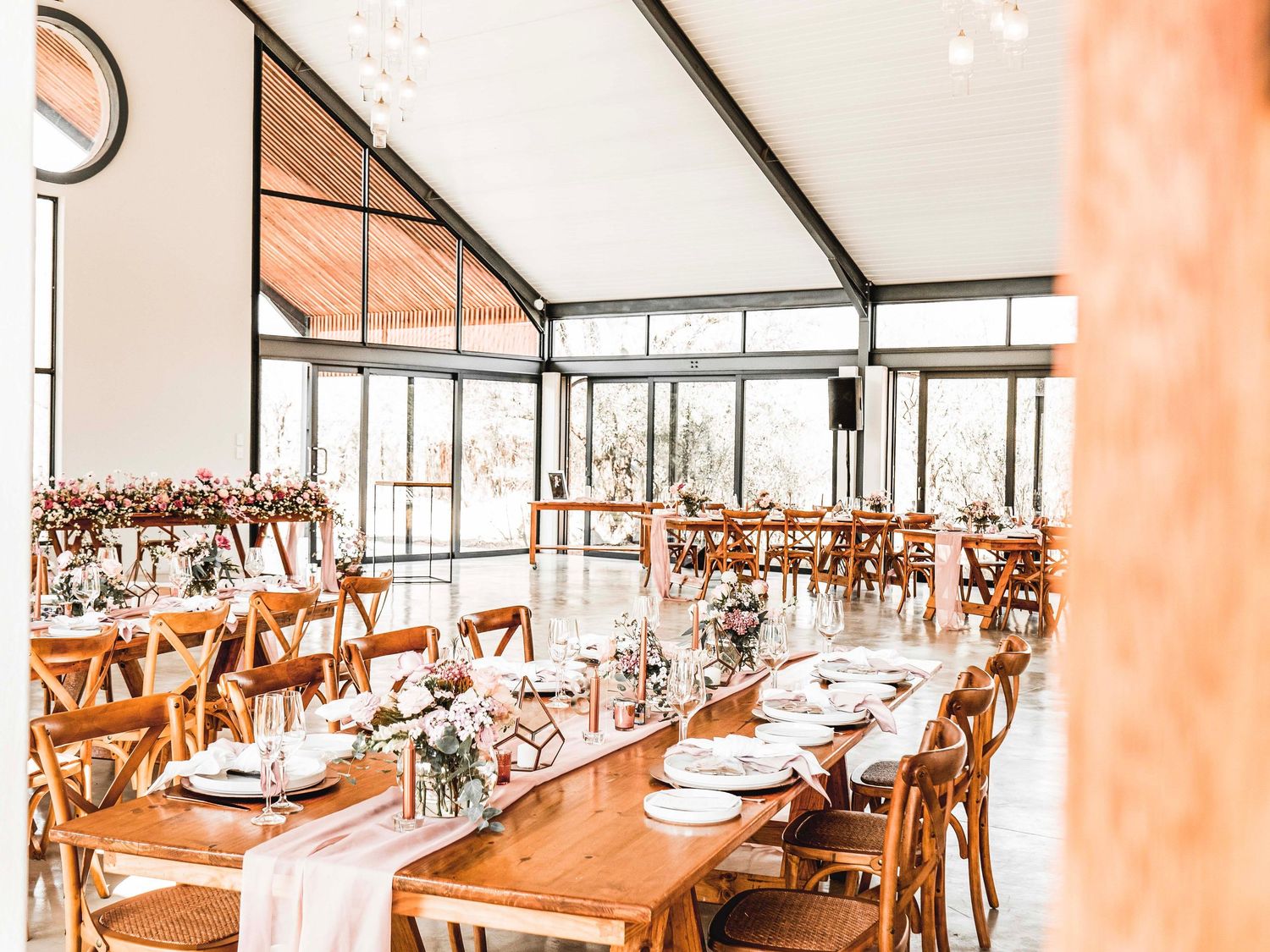 Long reception table set up with florals inside the wedding venue