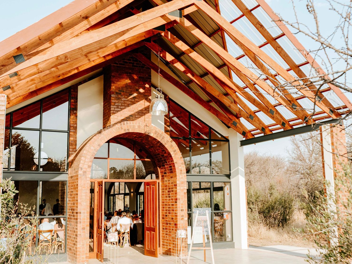 Exterior view of a timber-framed wedding venue with glass windows