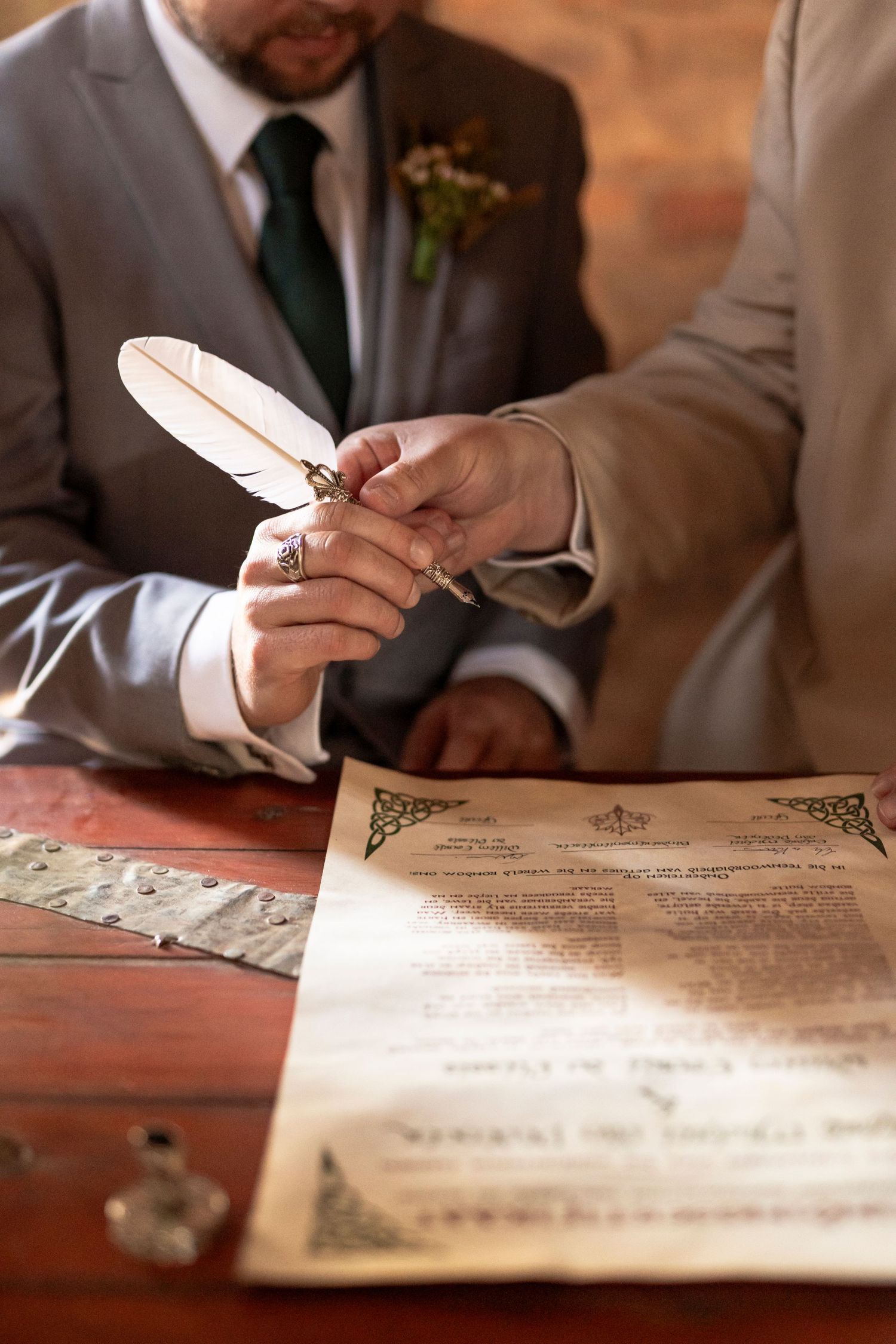 Groom signing the wedding binding certificate with a quill pen