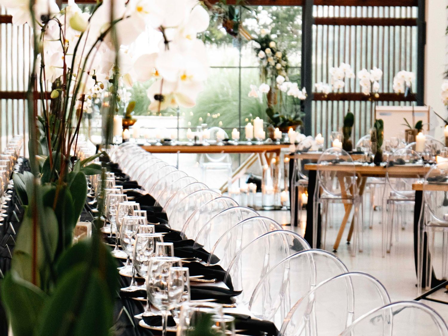 Long wedding reception table decorated with greenery in a glasshouse venue