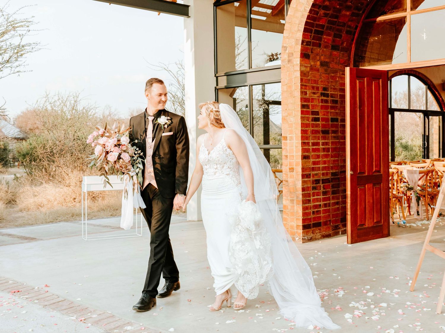 Bride and groom walking together outside a brick wedding venue building