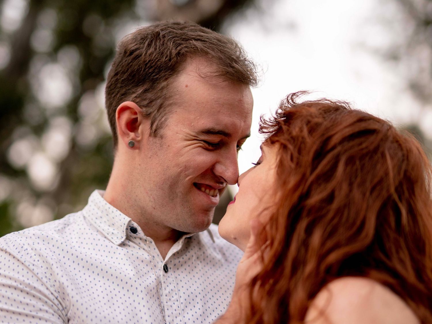 Man gently holding his partner's face in a tender engagement session moment