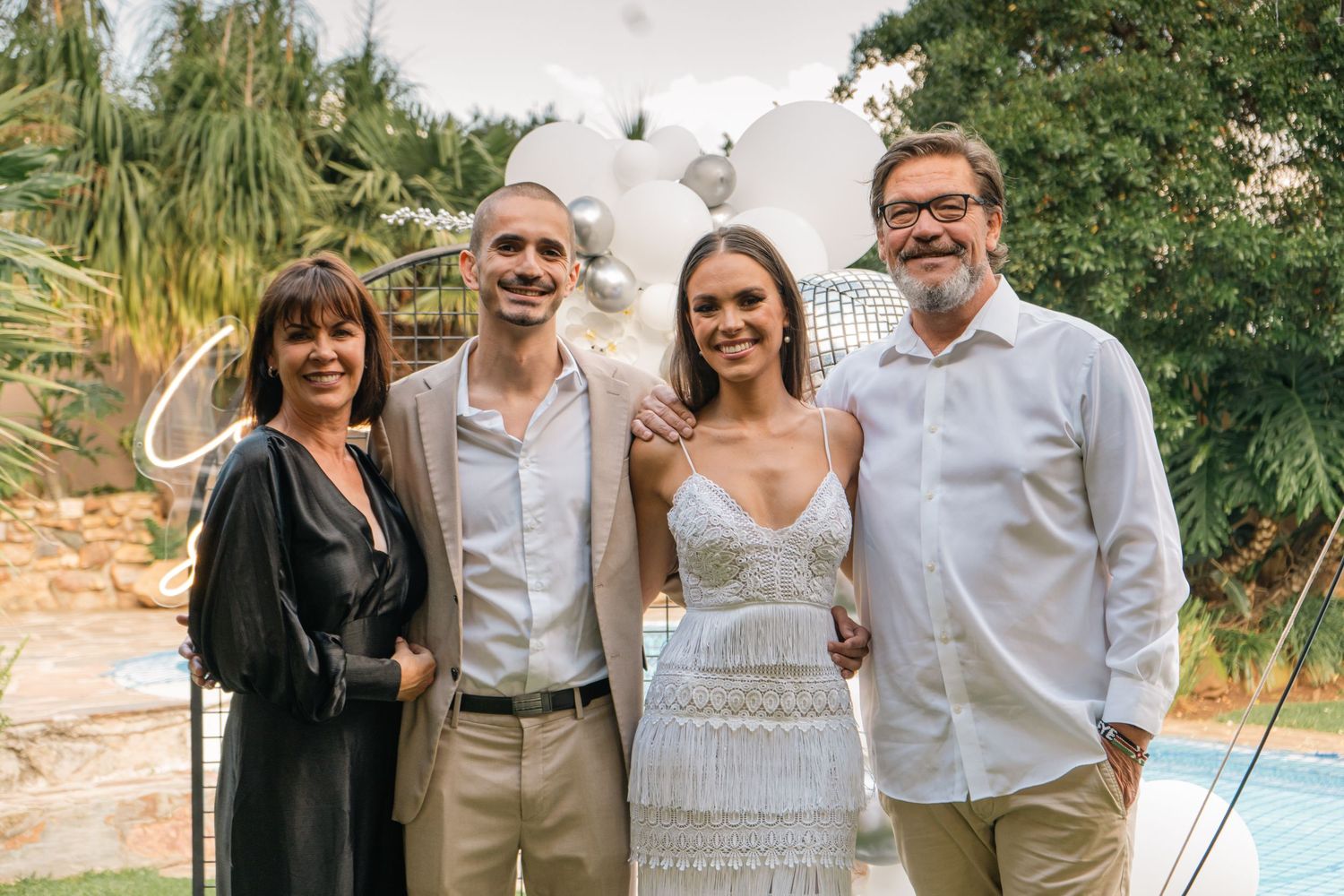 Two couples posing together outdoors at an engagement party celebration