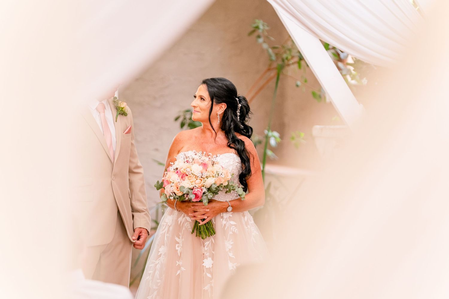 Bride descending a staircase holding her bouquet before the wedding ceremony