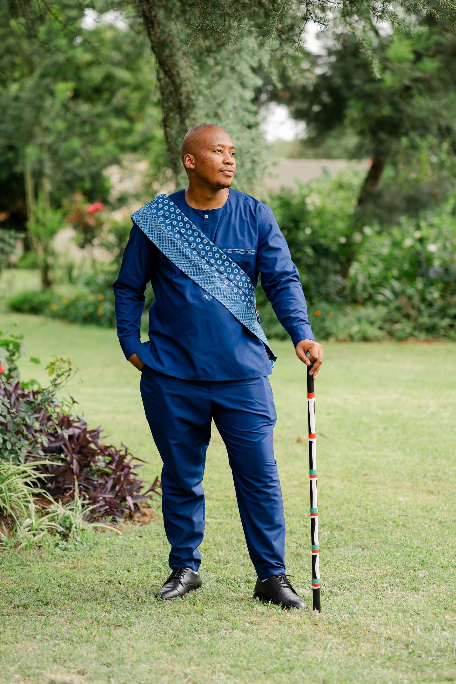 Groom in traditional blue wedding attire standing in a garden at his Gauteng wedding