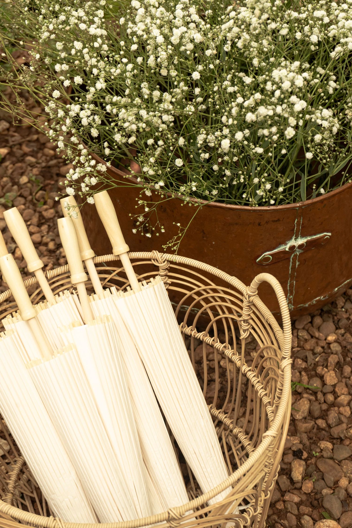 Wedding decor detail with white flowers and candles in a woven basket