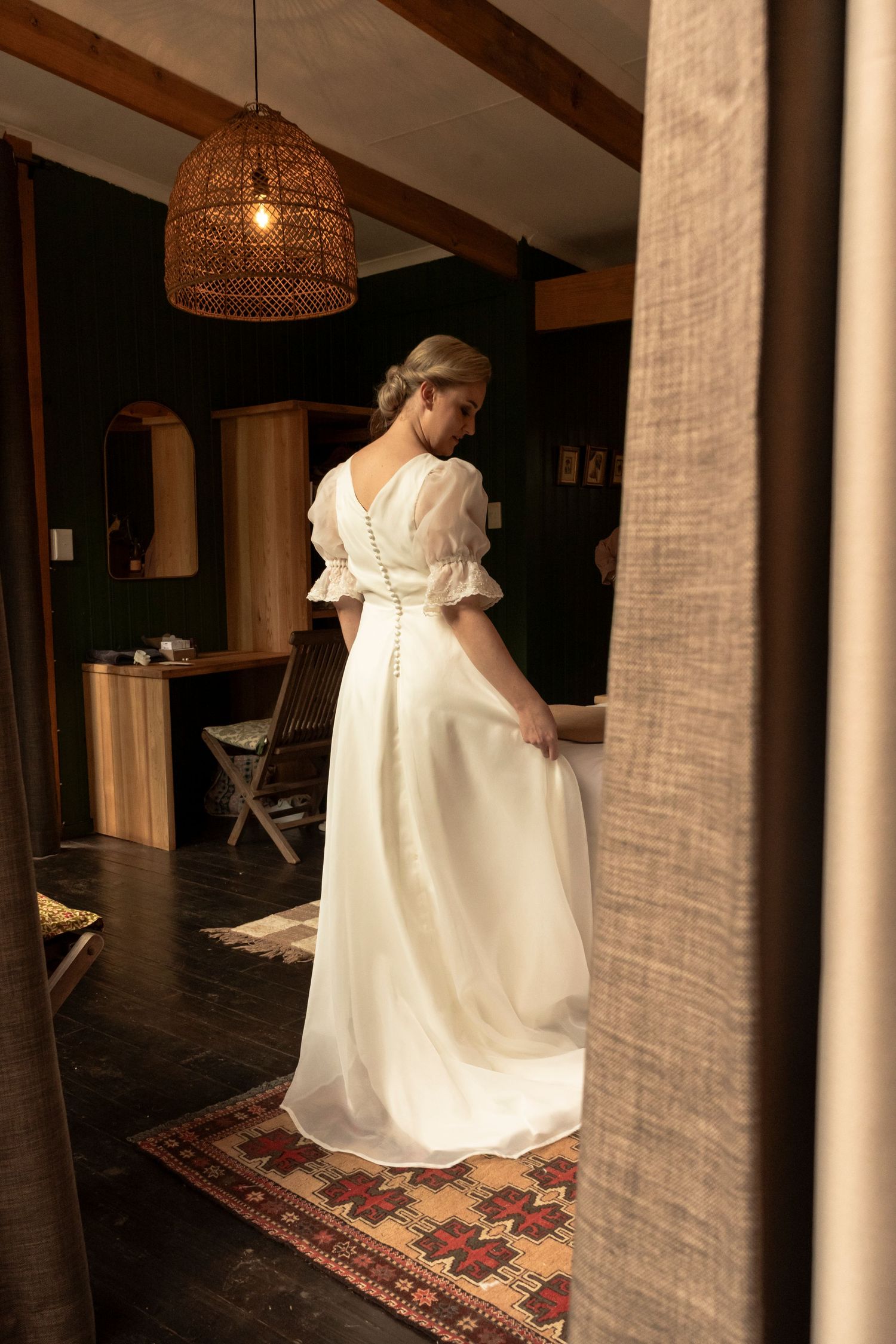 Bride in a white wedding dress standing in a doorway before the ceremony
