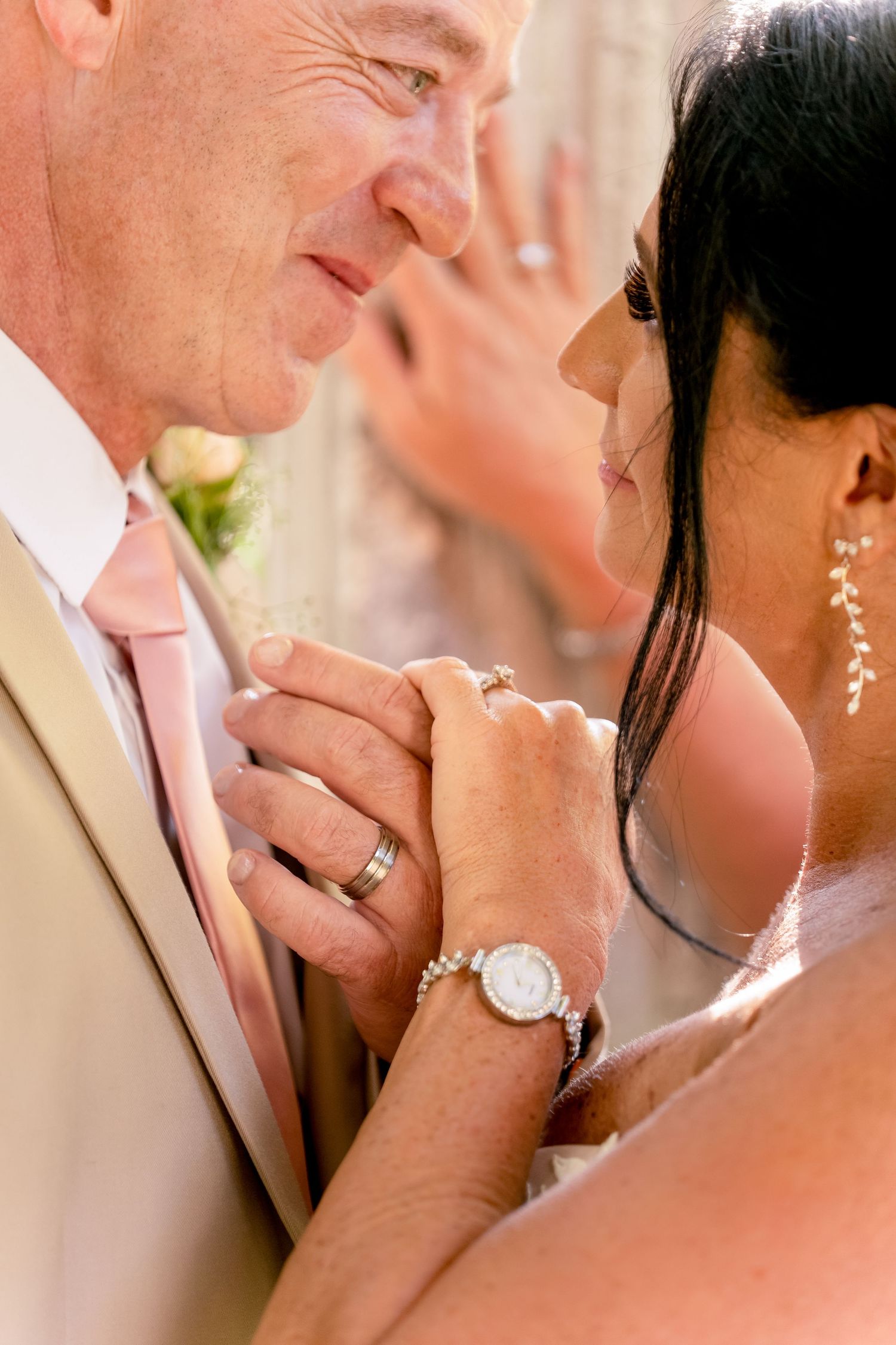 Emotional moment between the bride and her father holding hands before the ceremony