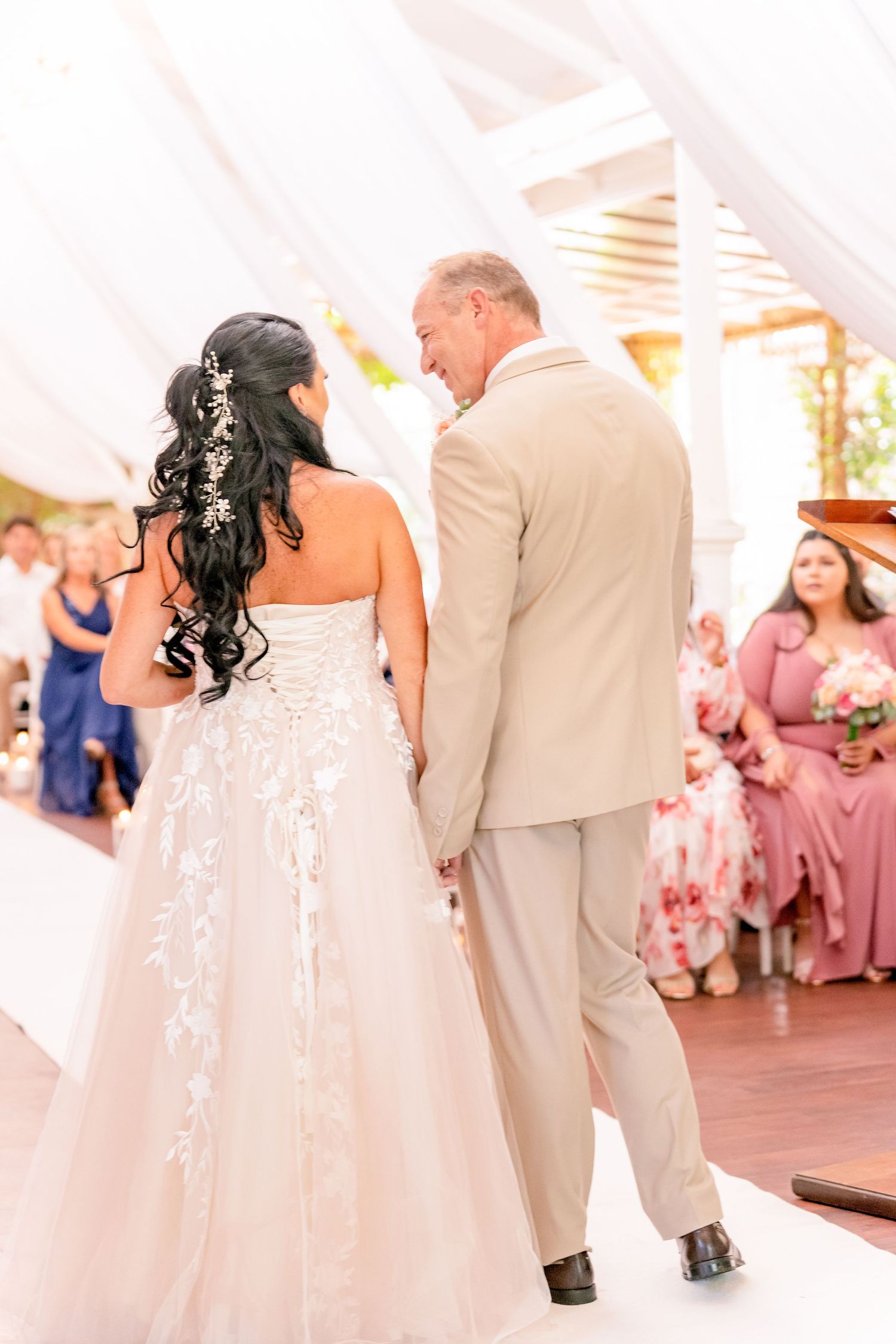 Bride walking down the aisle with her father past guests at the wedding ceremony