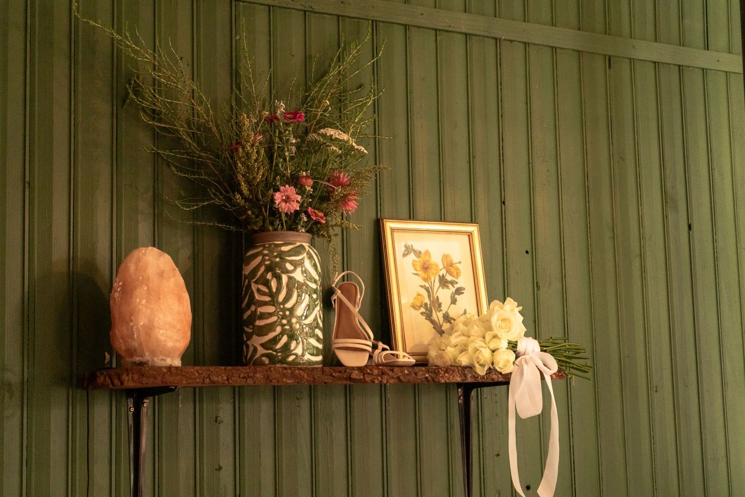 Wedding venue decor detail with flowers, a framed photo and small ornaments on a table